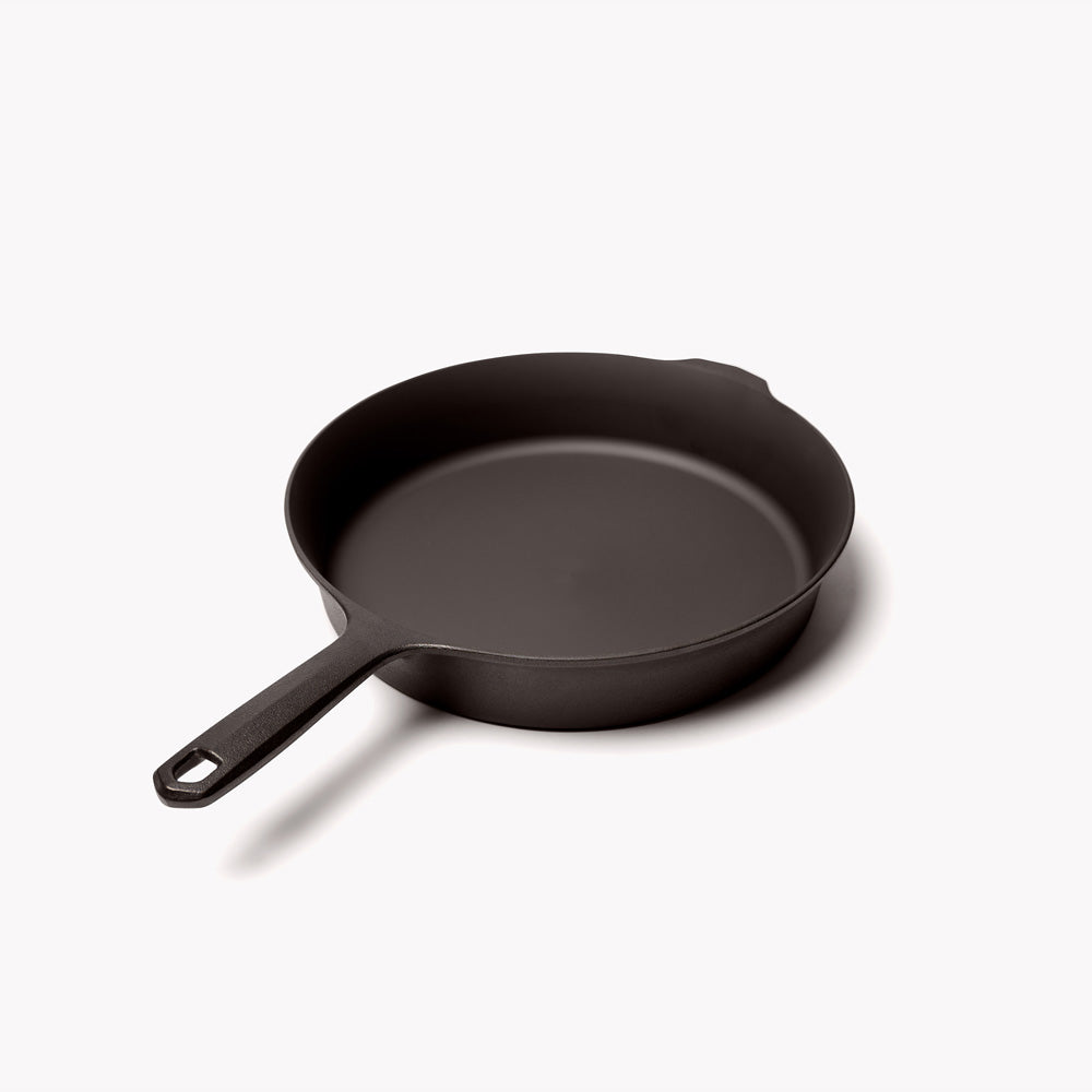 Black cast iron skillet with side handle and wide cooking rim