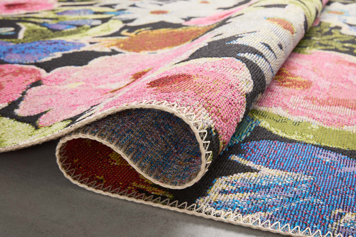 Rolled edge of botanical rug with multicolor floral design on dark base