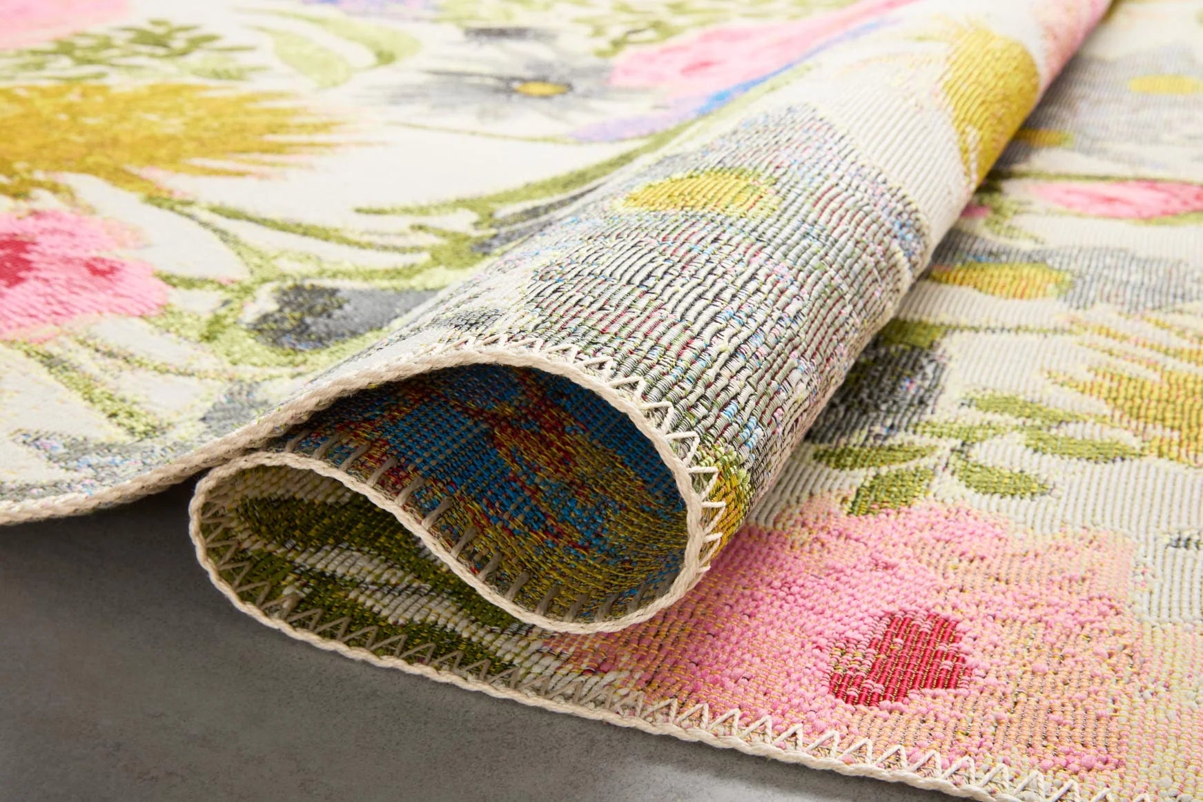 Ivory botanical runner rug corner with folded edge and multicolor floral pattern