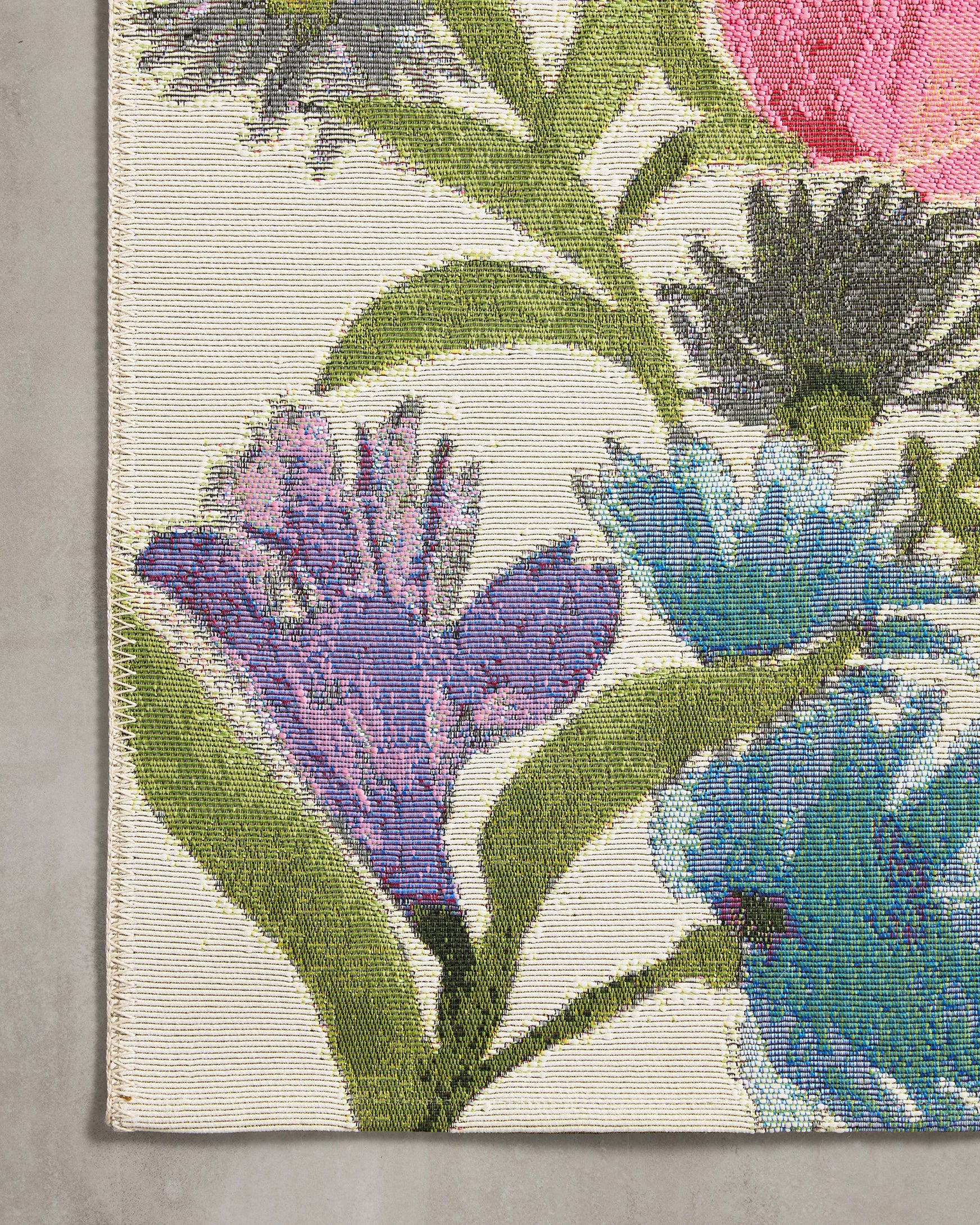 Ivory botanical runner rug with blue, pink, and green flower stems on a light base