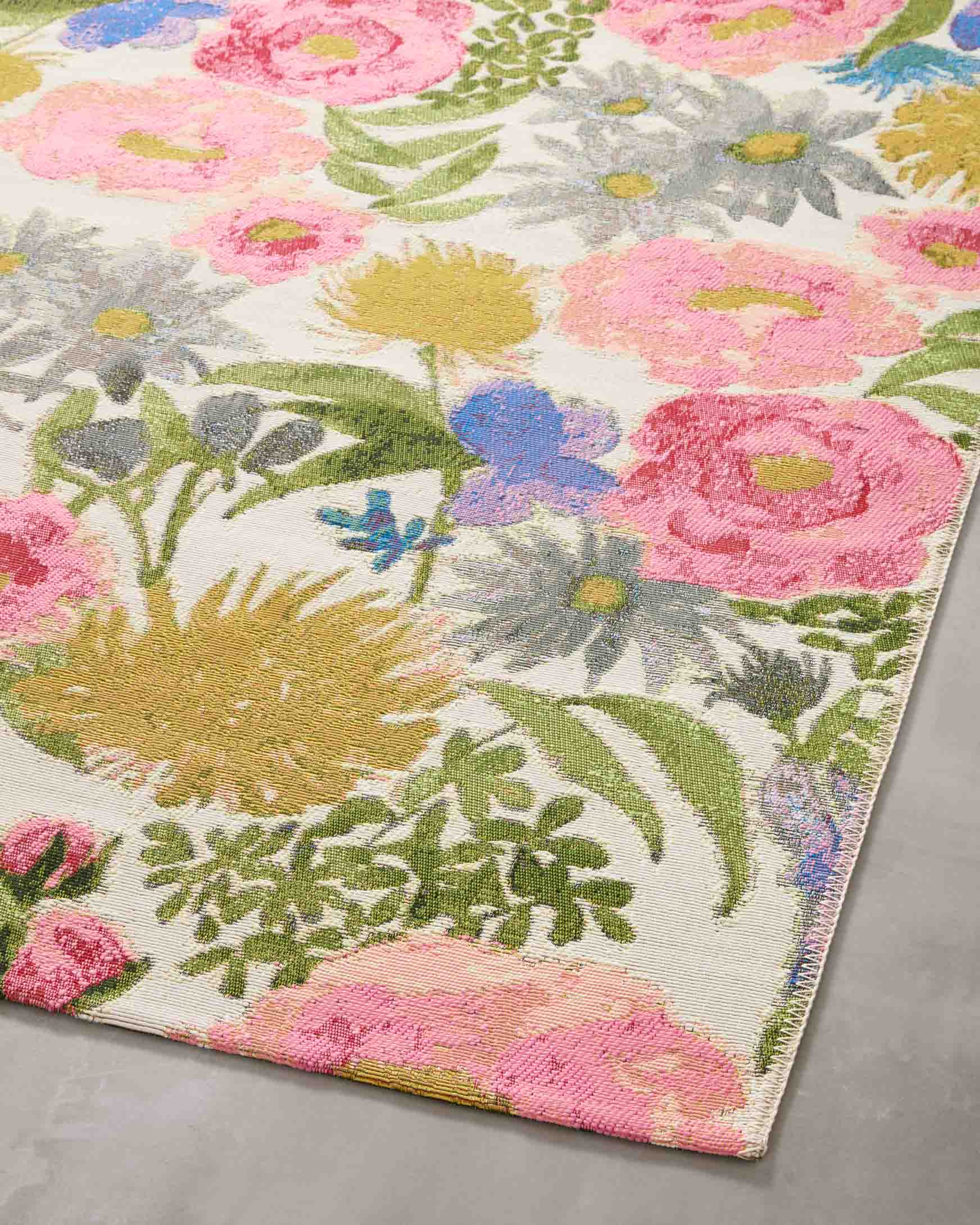 Ivory botanical runner rug laid flat with pink, blue, green, and yellow blossoms