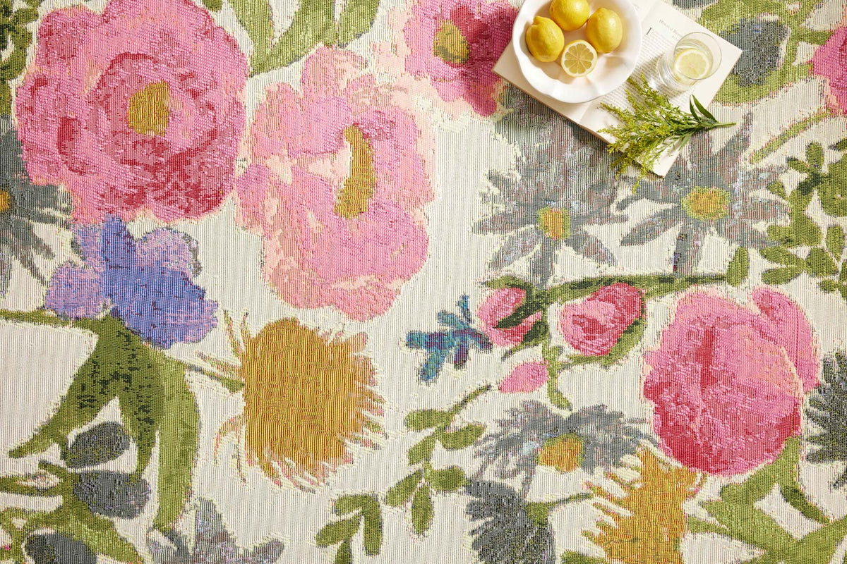 Close-up botanical rug showing pink and blue flowers with green leaves on light background