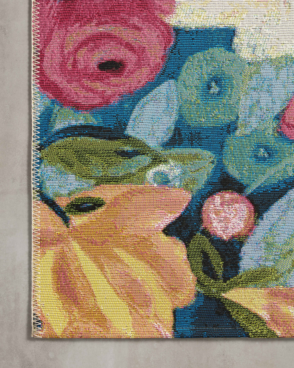Close-up of multicolor floral rug with stitched edge and textured fibers