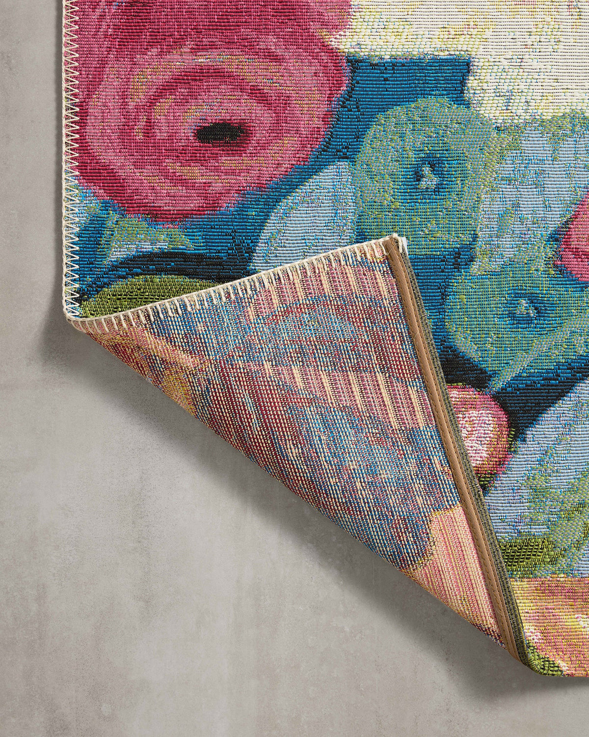 Multicolor rug corner showing textured weave and zigzag bound edge