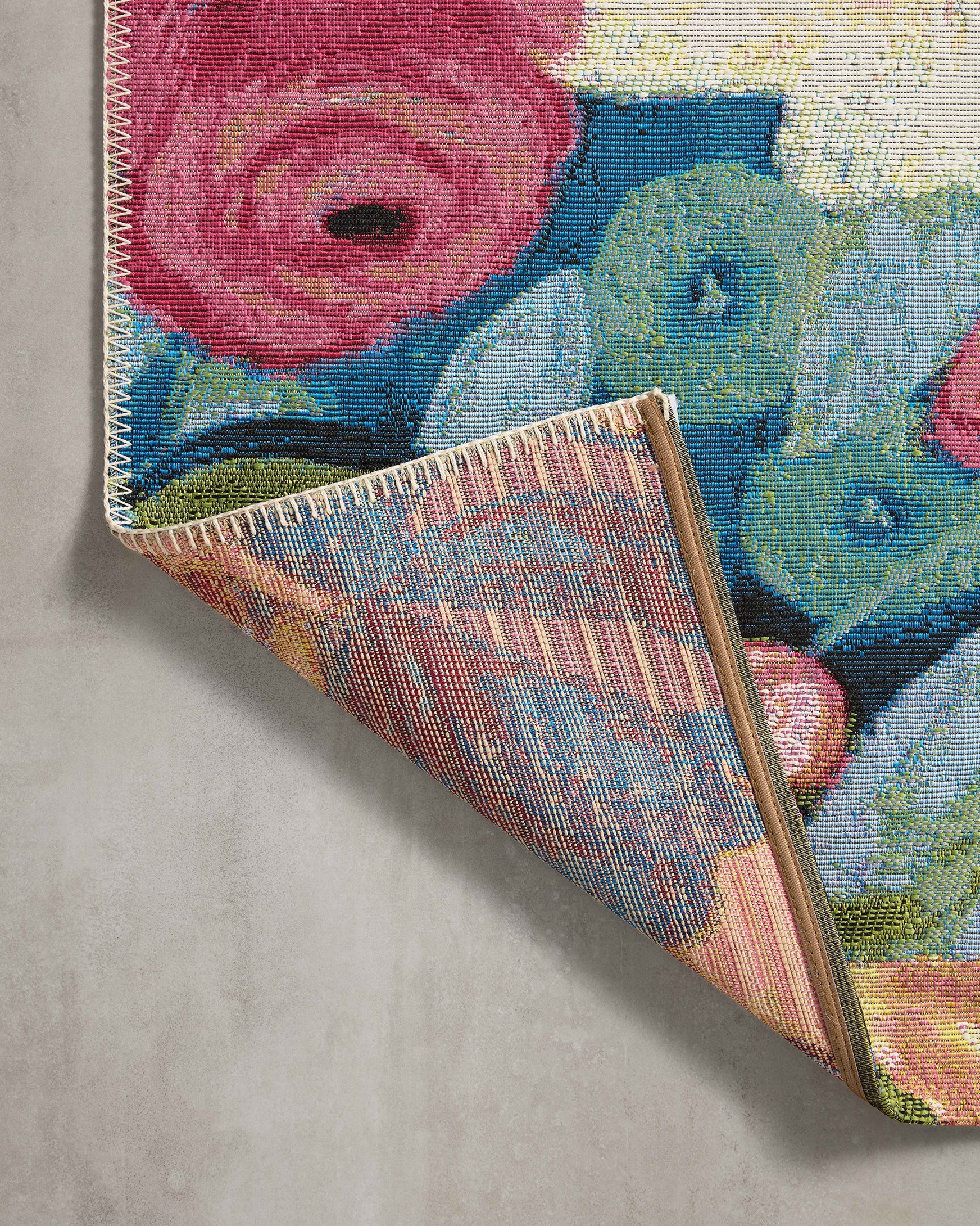 Corner detail of colorful botanical floral runner rug with stitched binding