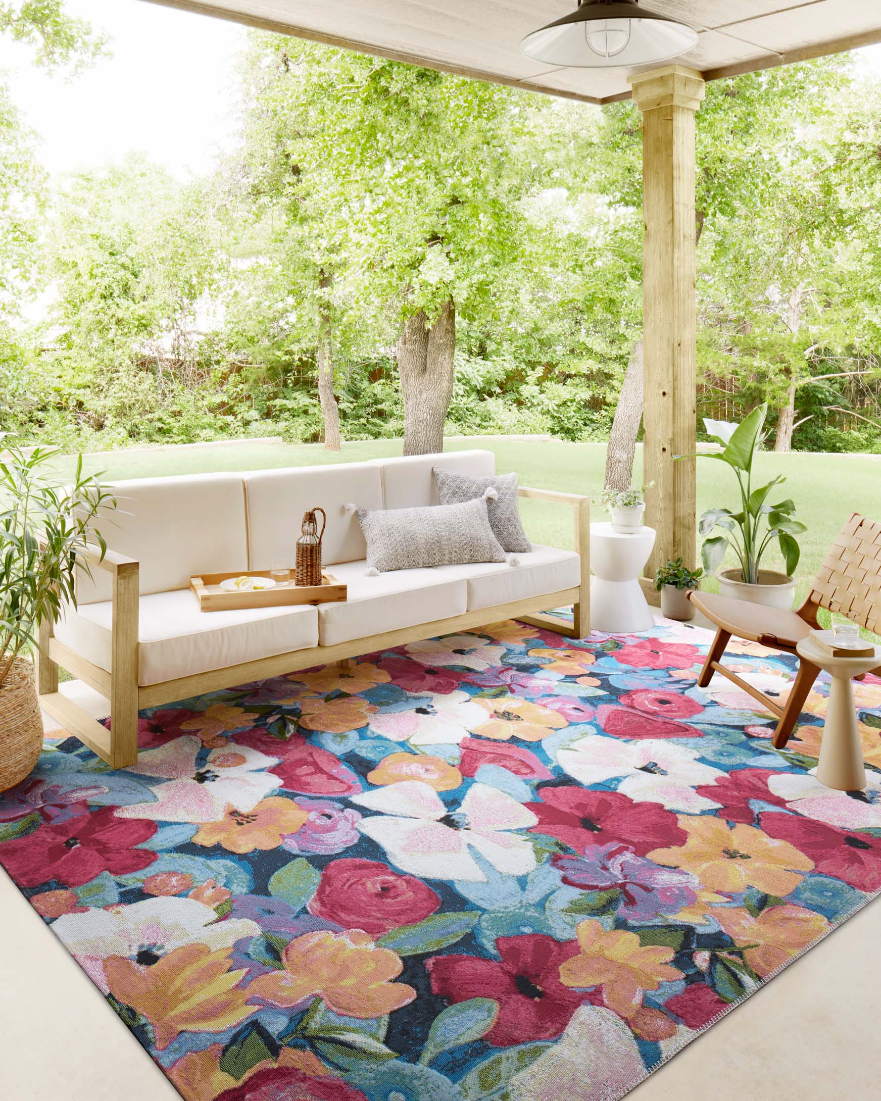 Multicolor floral indoor/outdoor accent rug under patio seating and planters