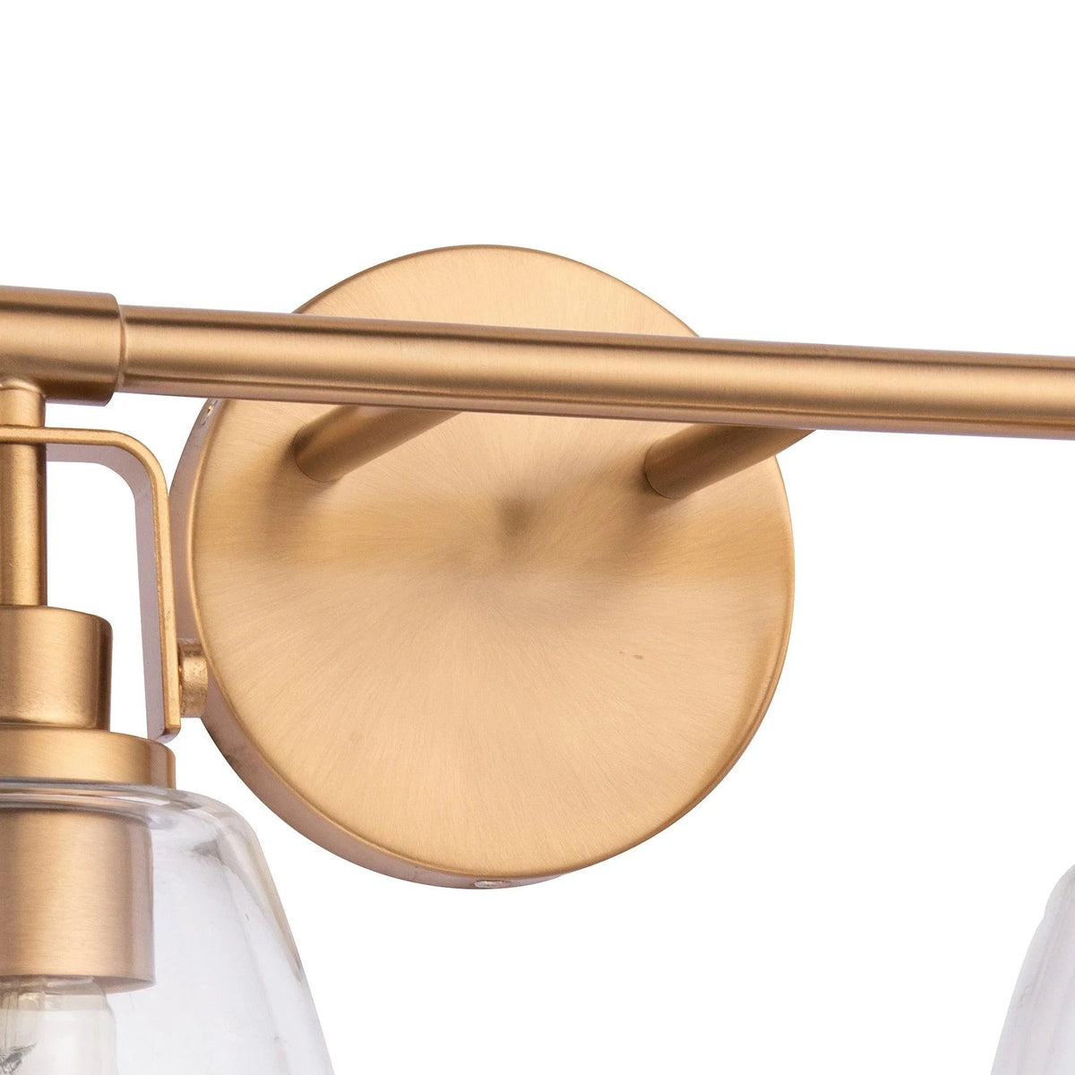 Golden wall-mounted vanity light backplate with clear glass shade and metal socket.