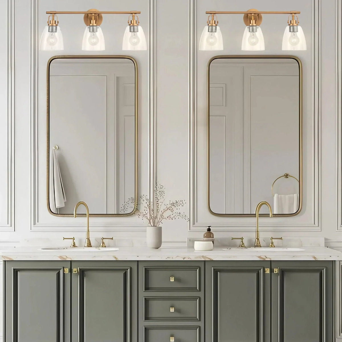 Three-bulb vanity light with golden bar and clear glass bell shades above mirror