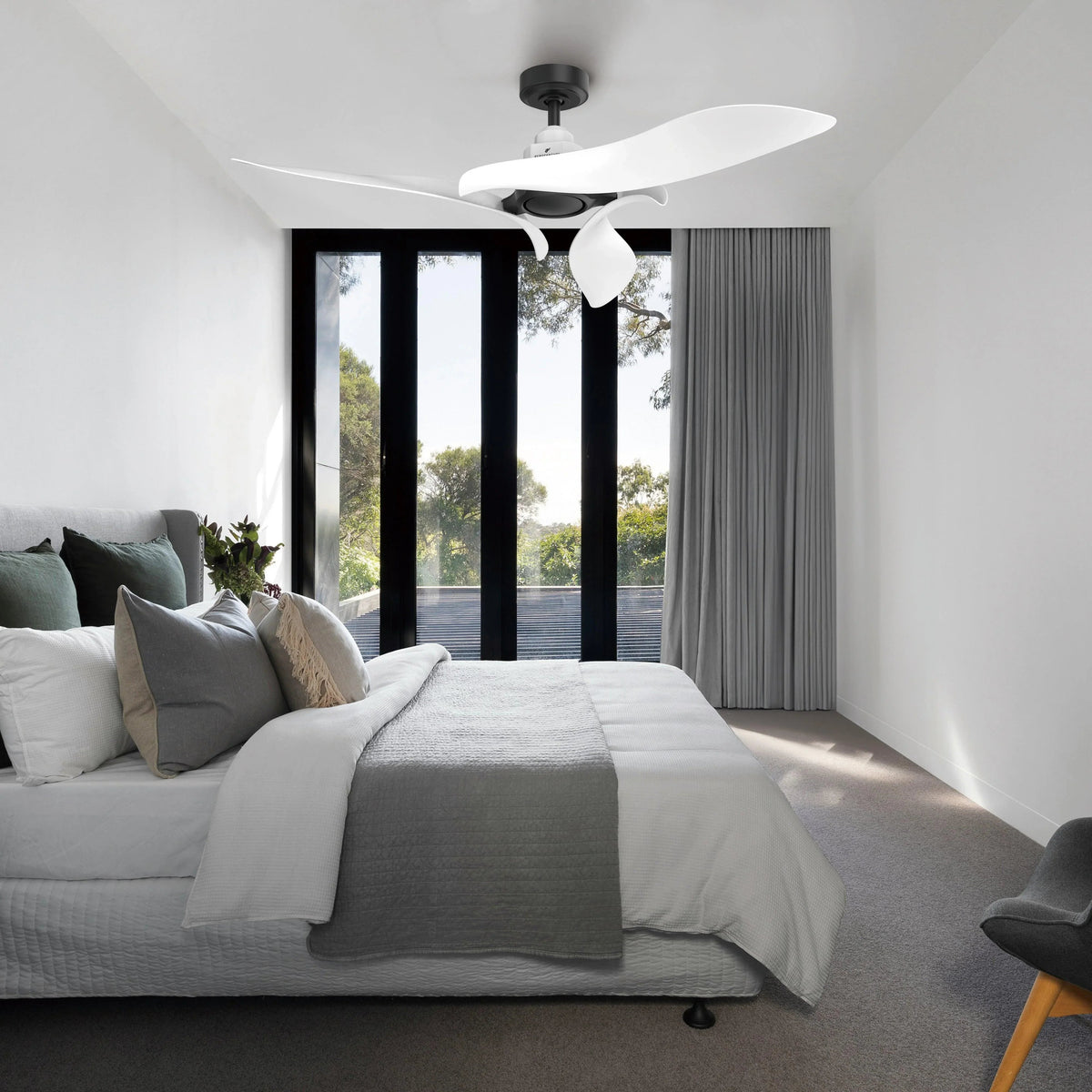 Ceiling fan with black mount and white blades above a modern bedroom
