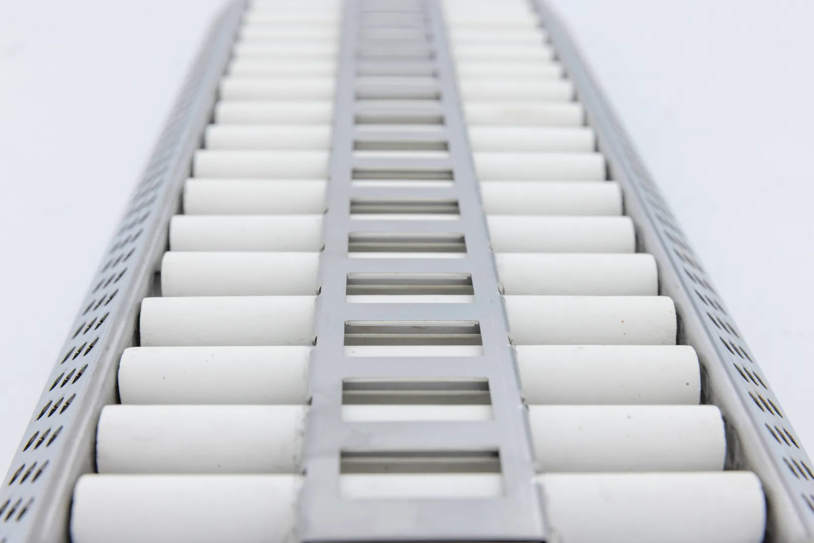 Ceramic tube grate with parallel white ceramic cylinders and central support rails
