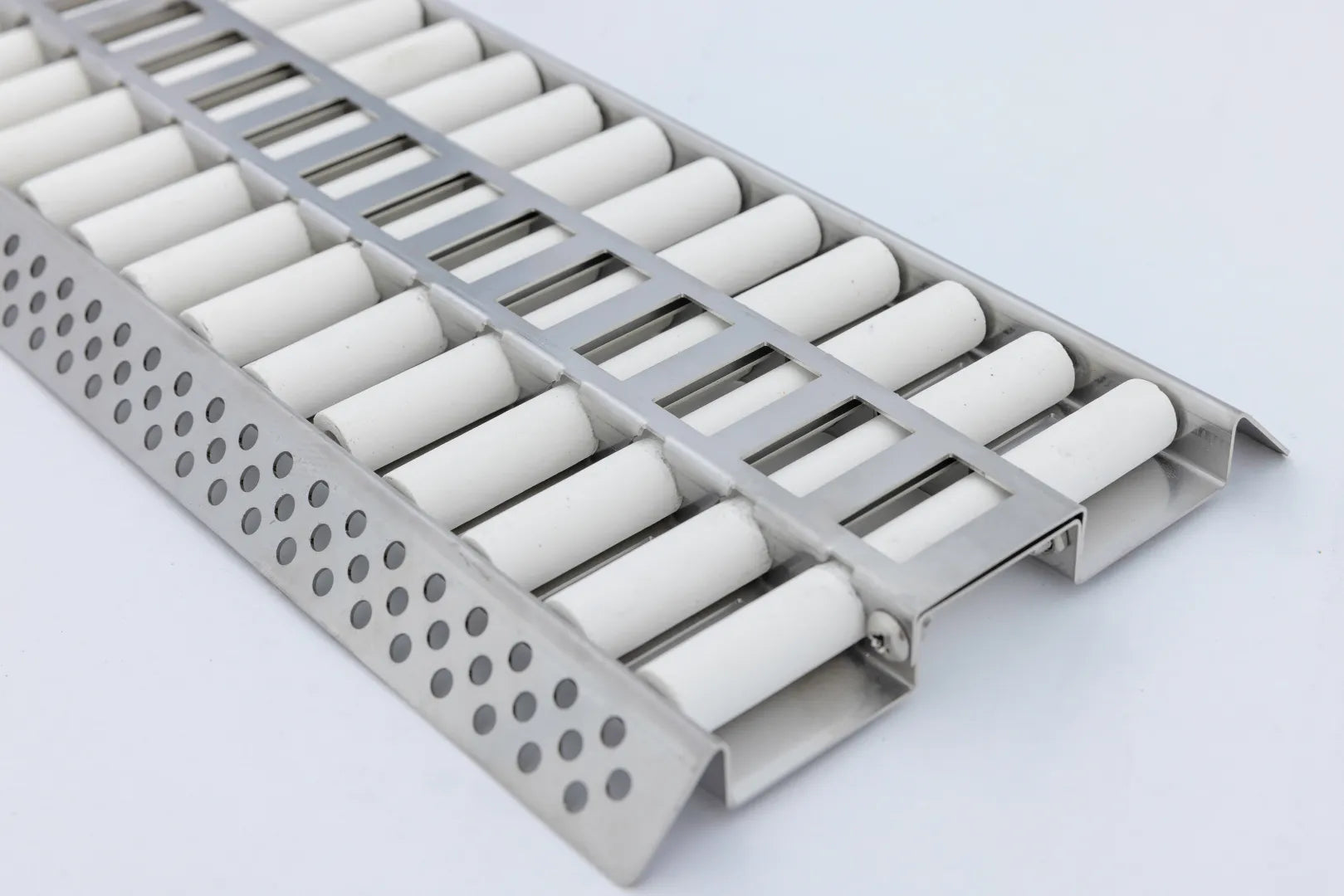 Ceramic flame tamer with angled row of white tubes and perforated metal edge