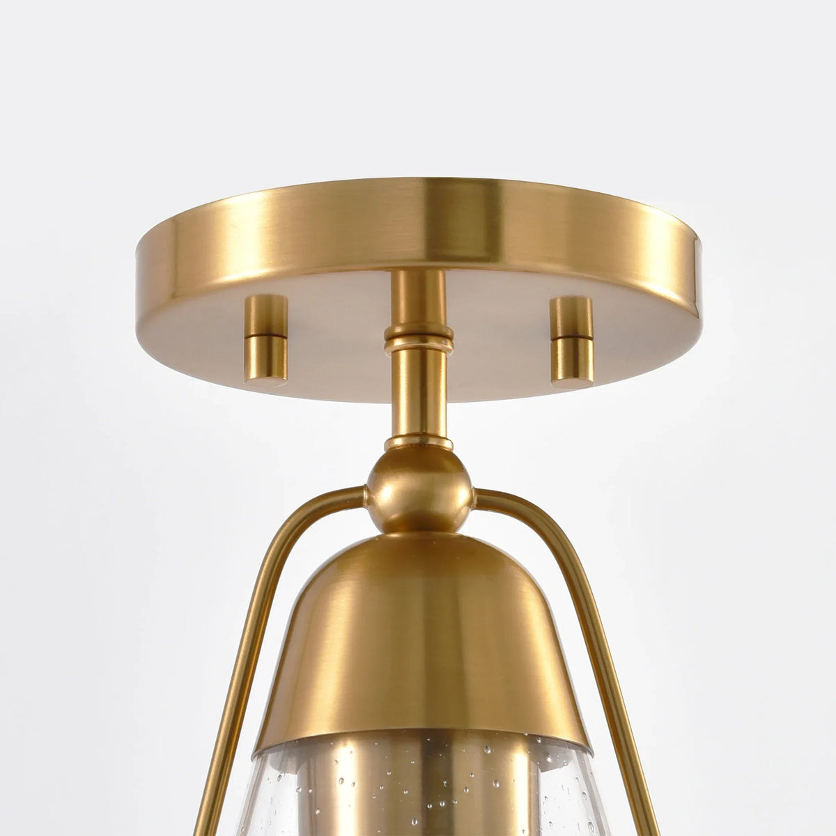 Golden semi-flush mount ceiling light canopy with curved support and clear seeded glass shade