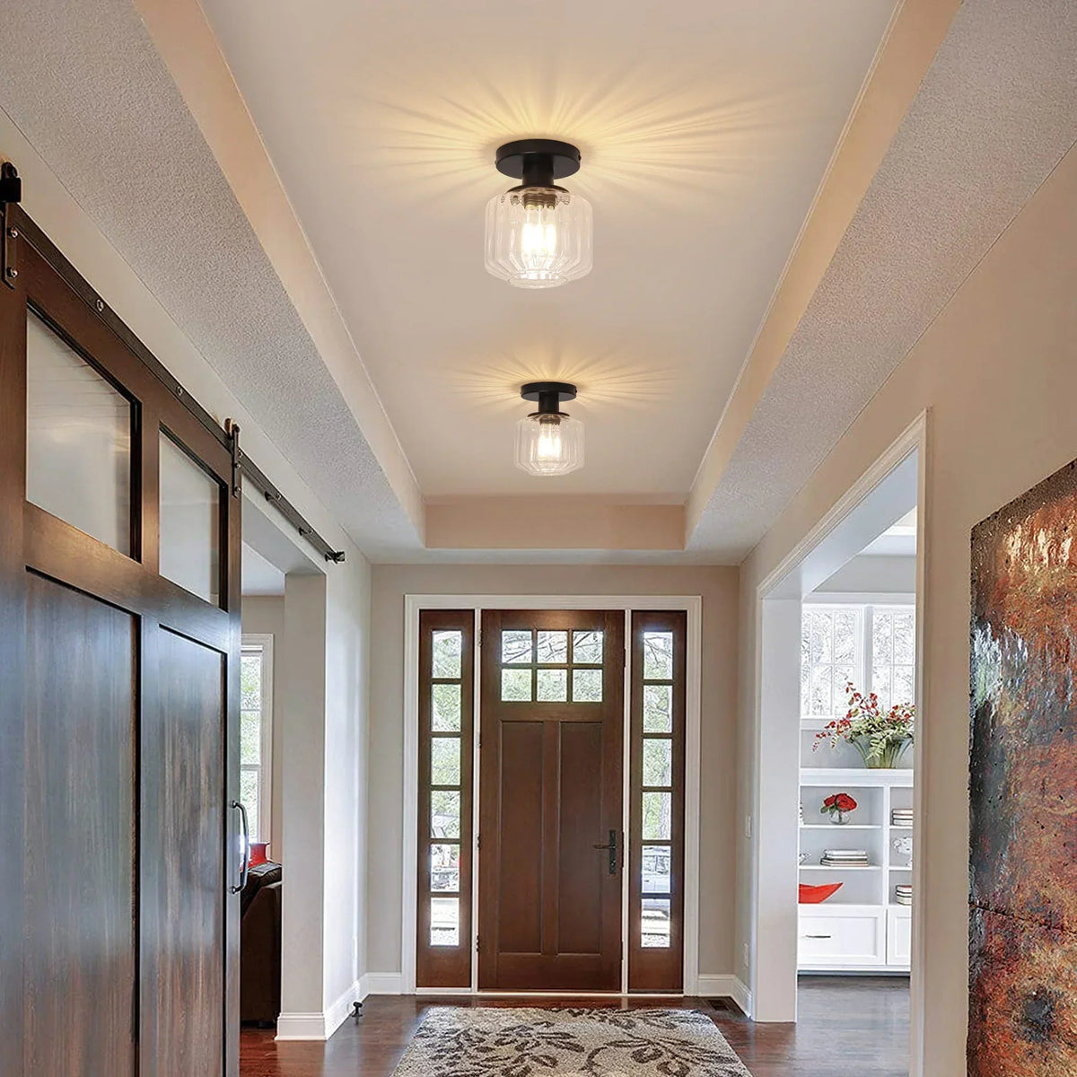 Black semi-flush mount ceiling light with clear glass shade in an entry hallway