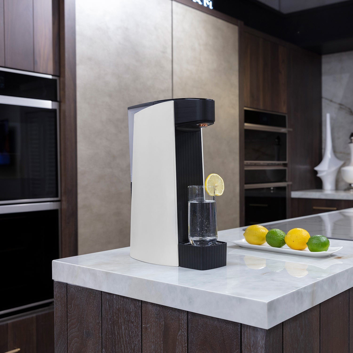 White sparkling water maker dispensing water on a kitchen counter with lemon slices