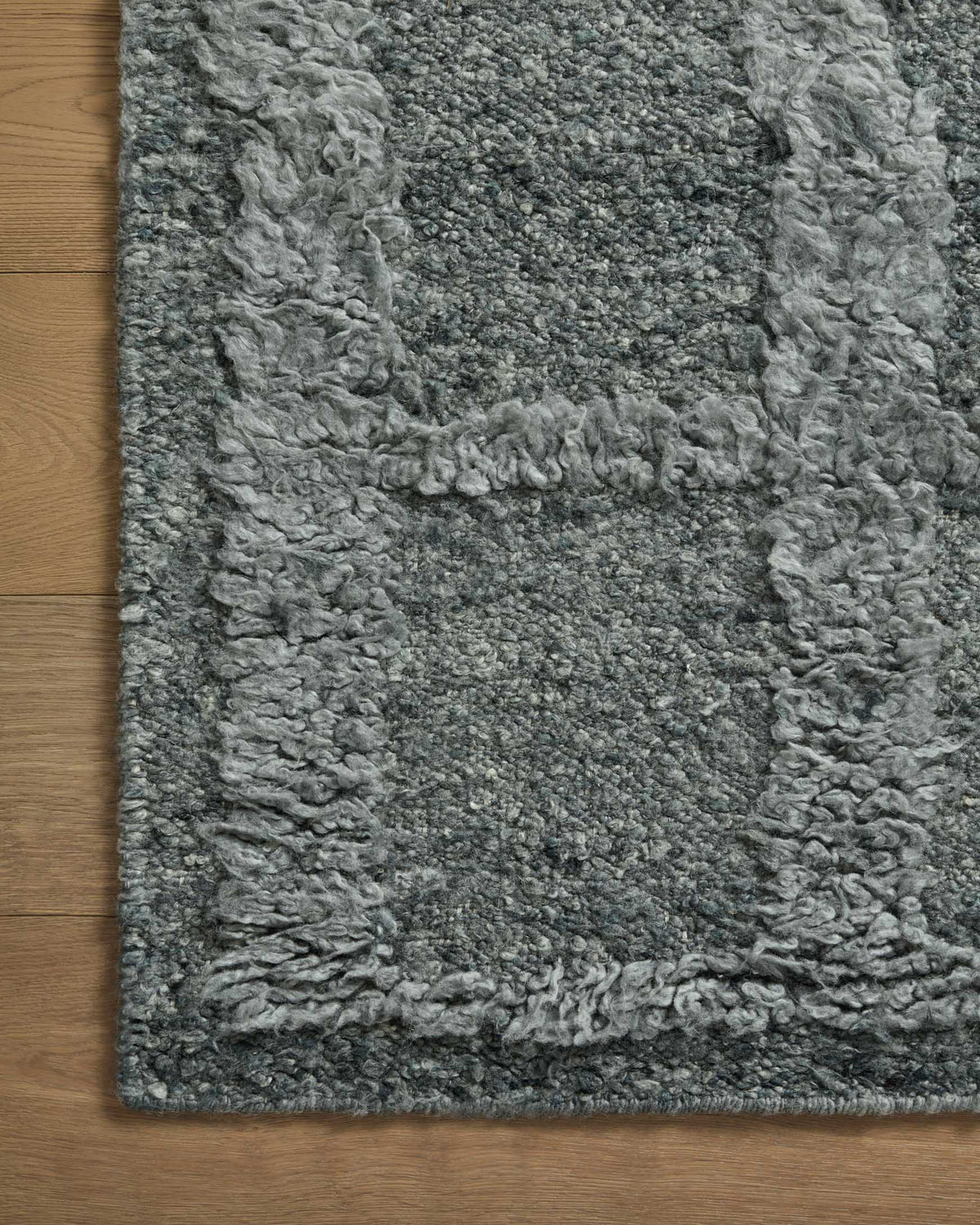 Gray high-pile shag rug with dense loop texture and bound edge, close-up