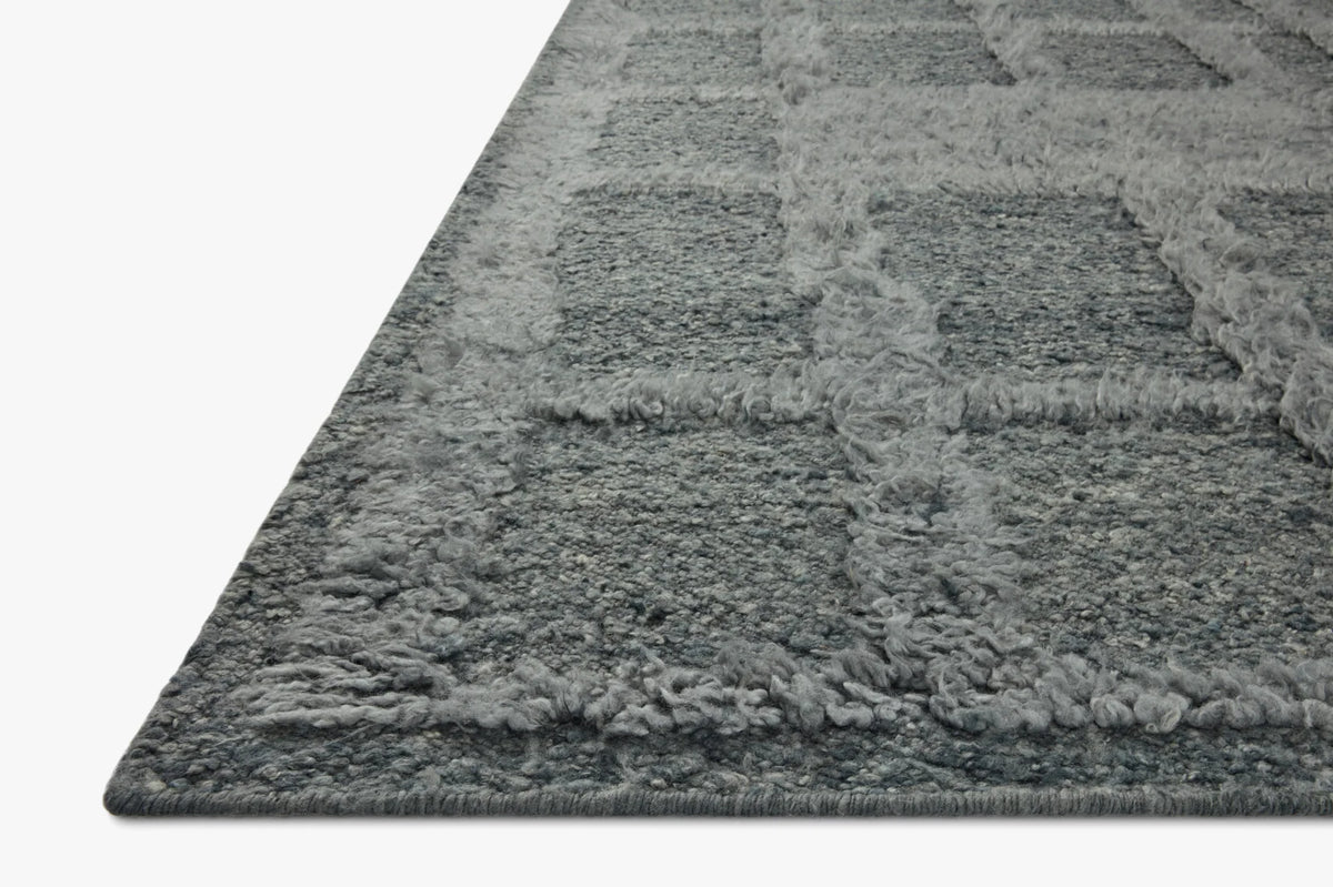 Denim-blue area rug with thick textured pile, corner angle view