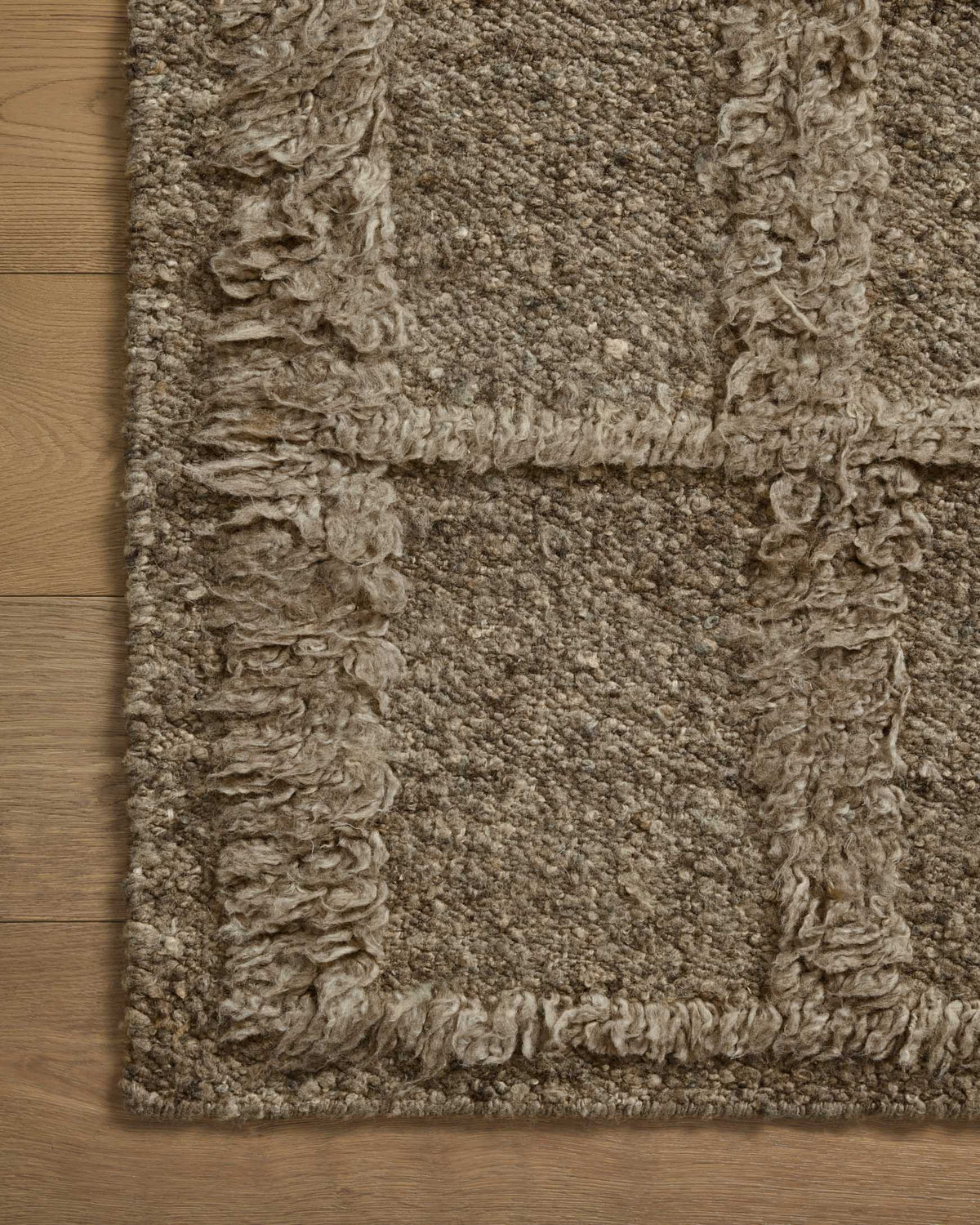Textured area rug close-up with raised loop pattern and short pile, muted sage