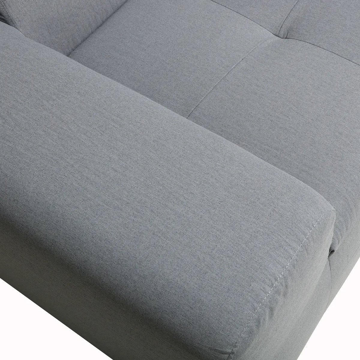 Gray upholstered sofa cushion with curved arm and stitched seam