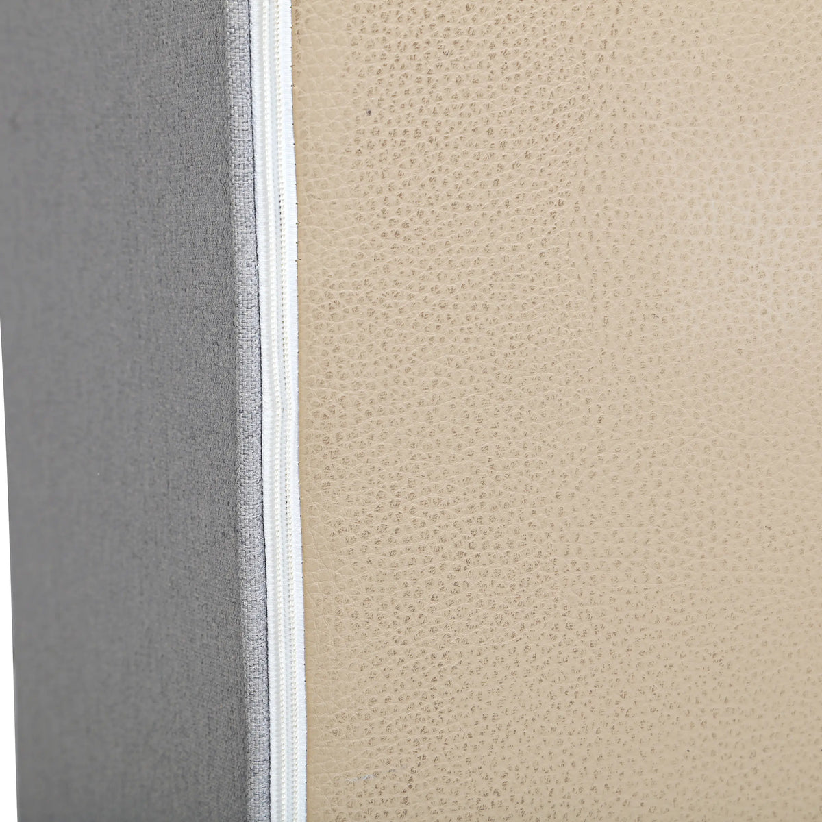 Close-up of gray fabric upholstery texture and white piping along the edge