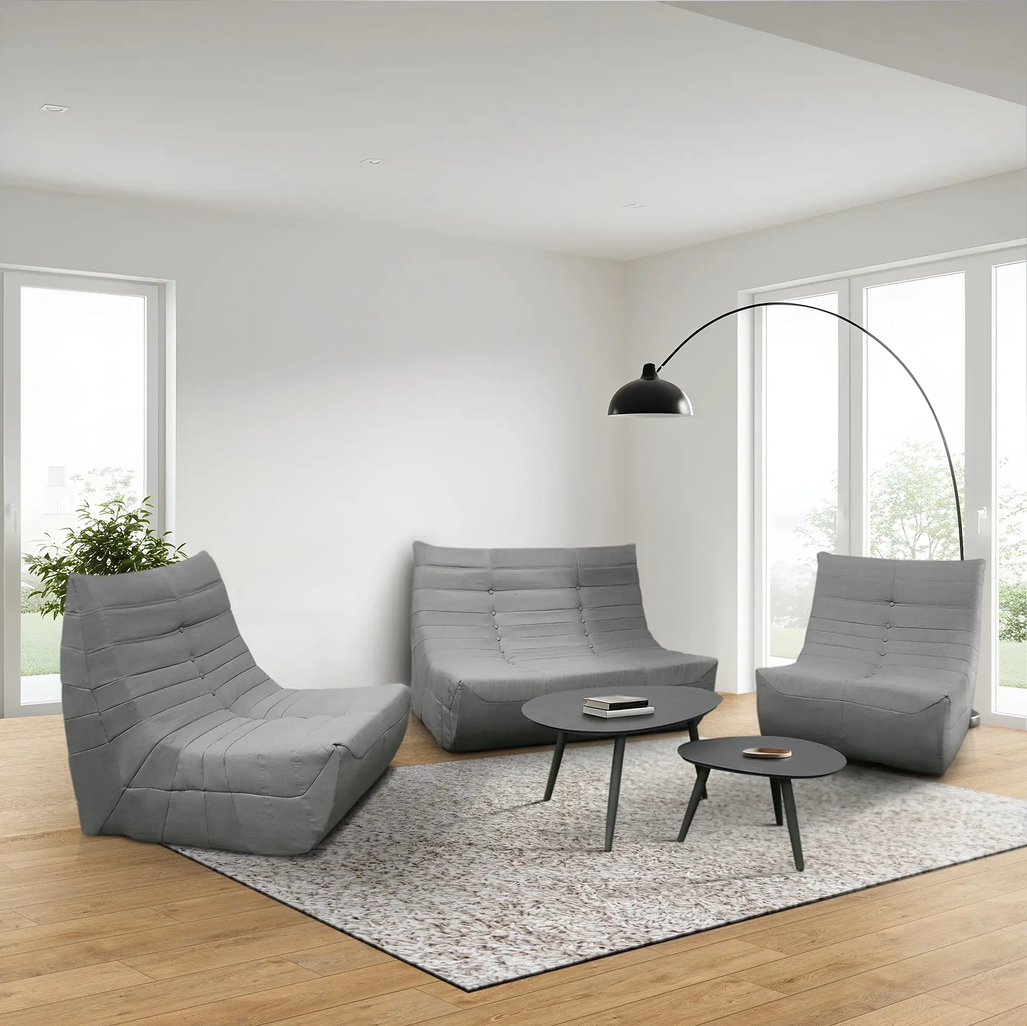 Gray sofa, two armchairs, and round coffee table set with tufted cushions