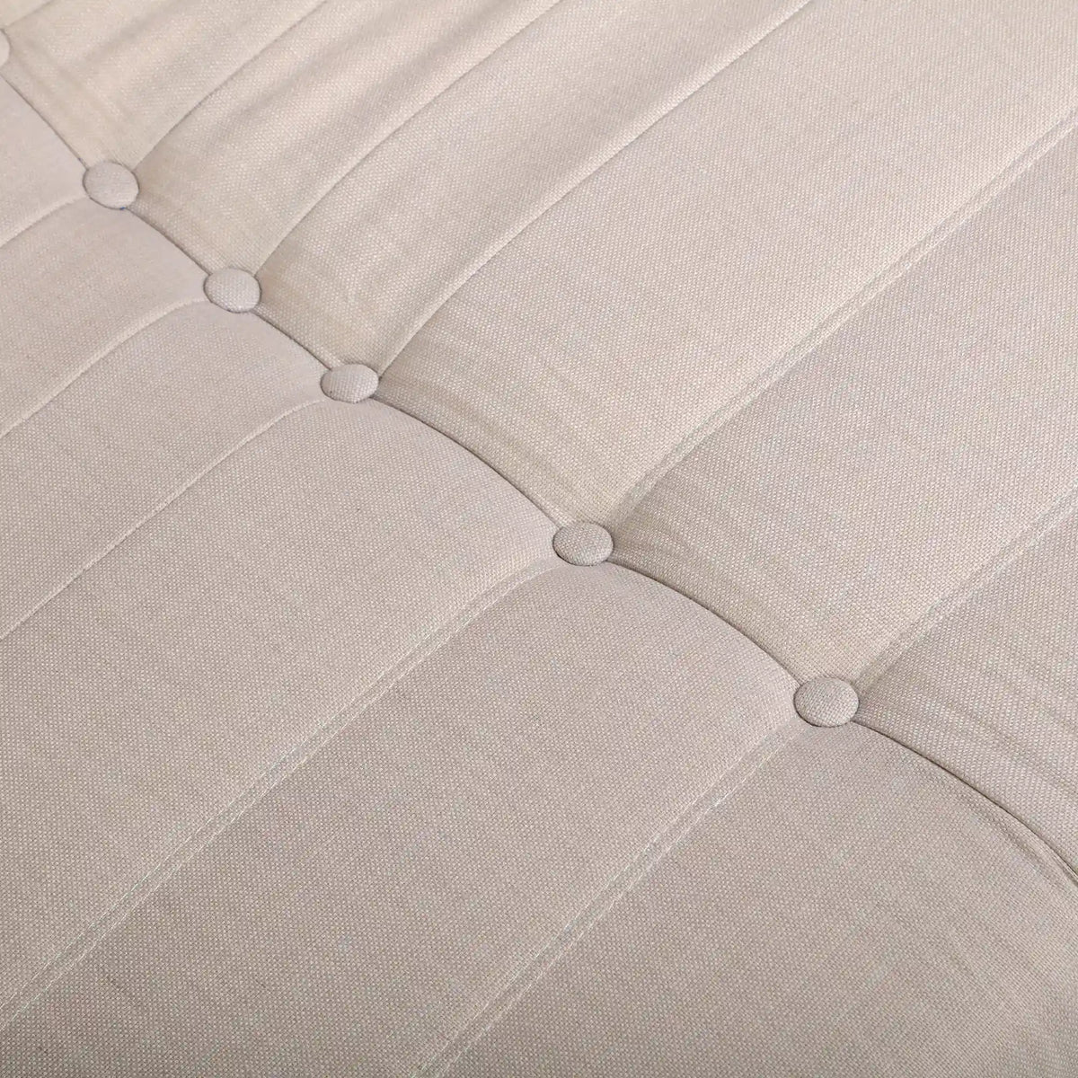 Beige sofa back detail with button tufting and quilted seam lines.