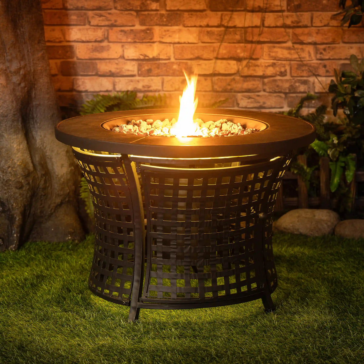 Black outdoor propane fire pit table with open flame center and lava rocks