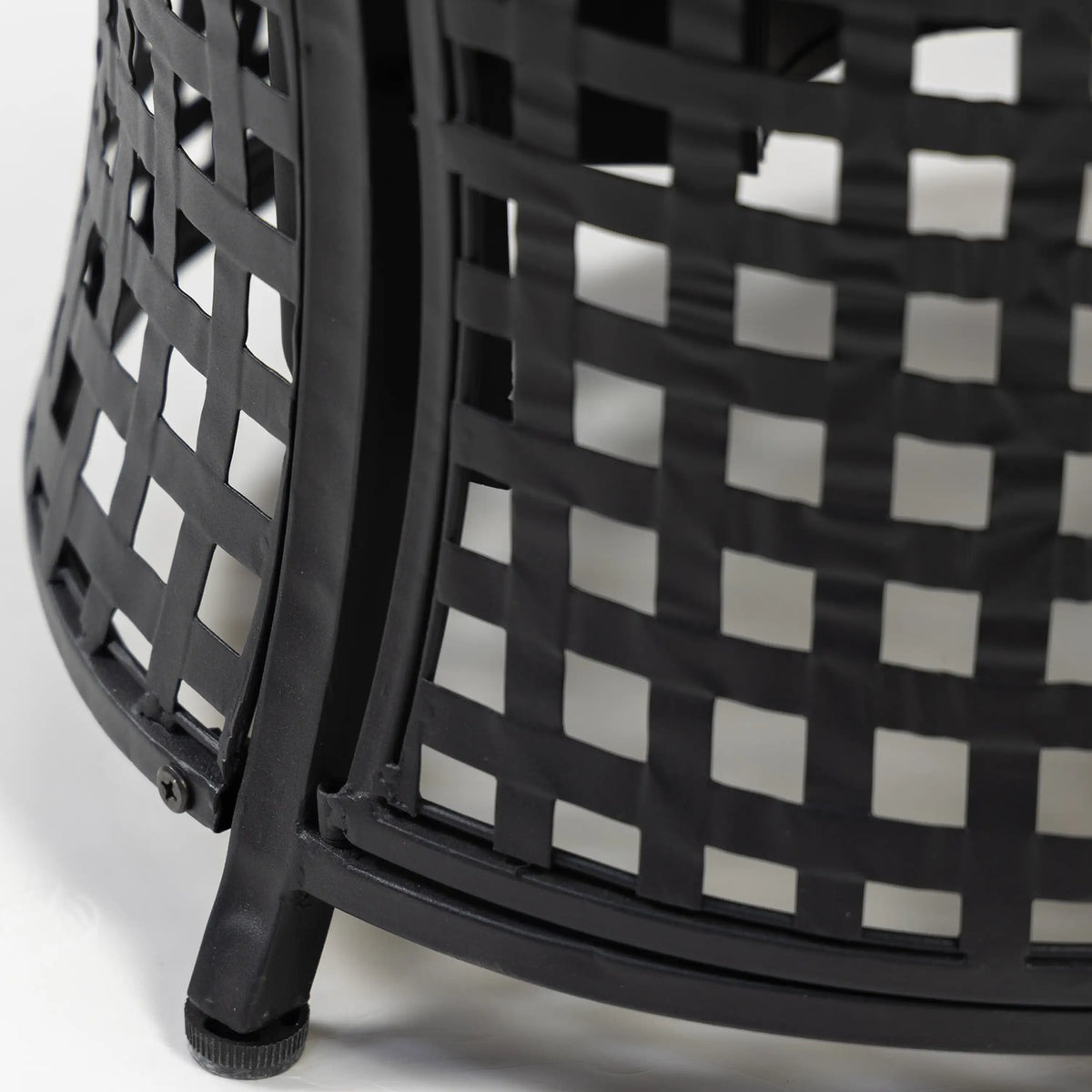 Black woven metal lattice side of an outdoor propane fire pit table