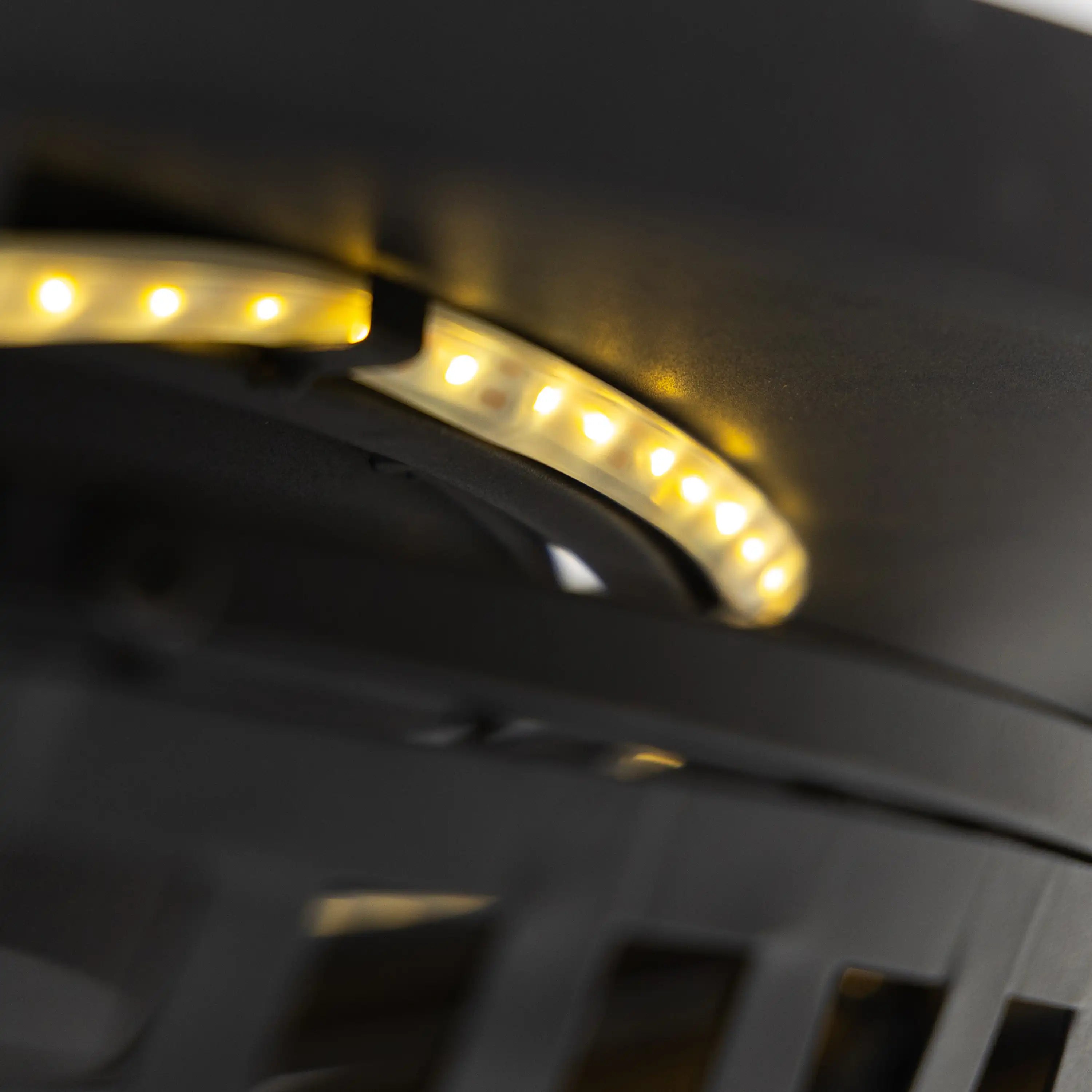 Close-up of glowing burner holes under a black fire pit top