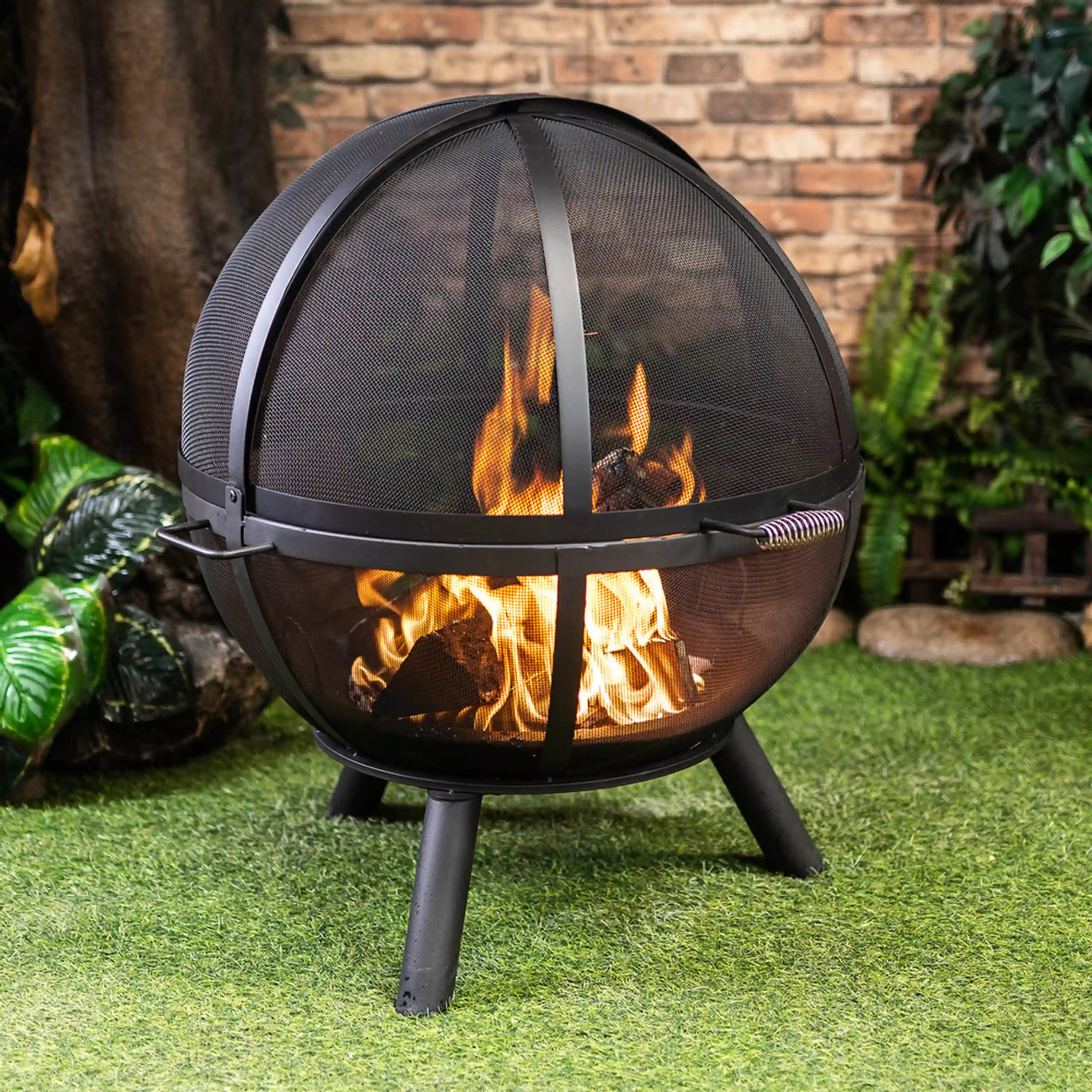 Outdoor sphere fire pit with black mesh dome and burning flames, front guard band