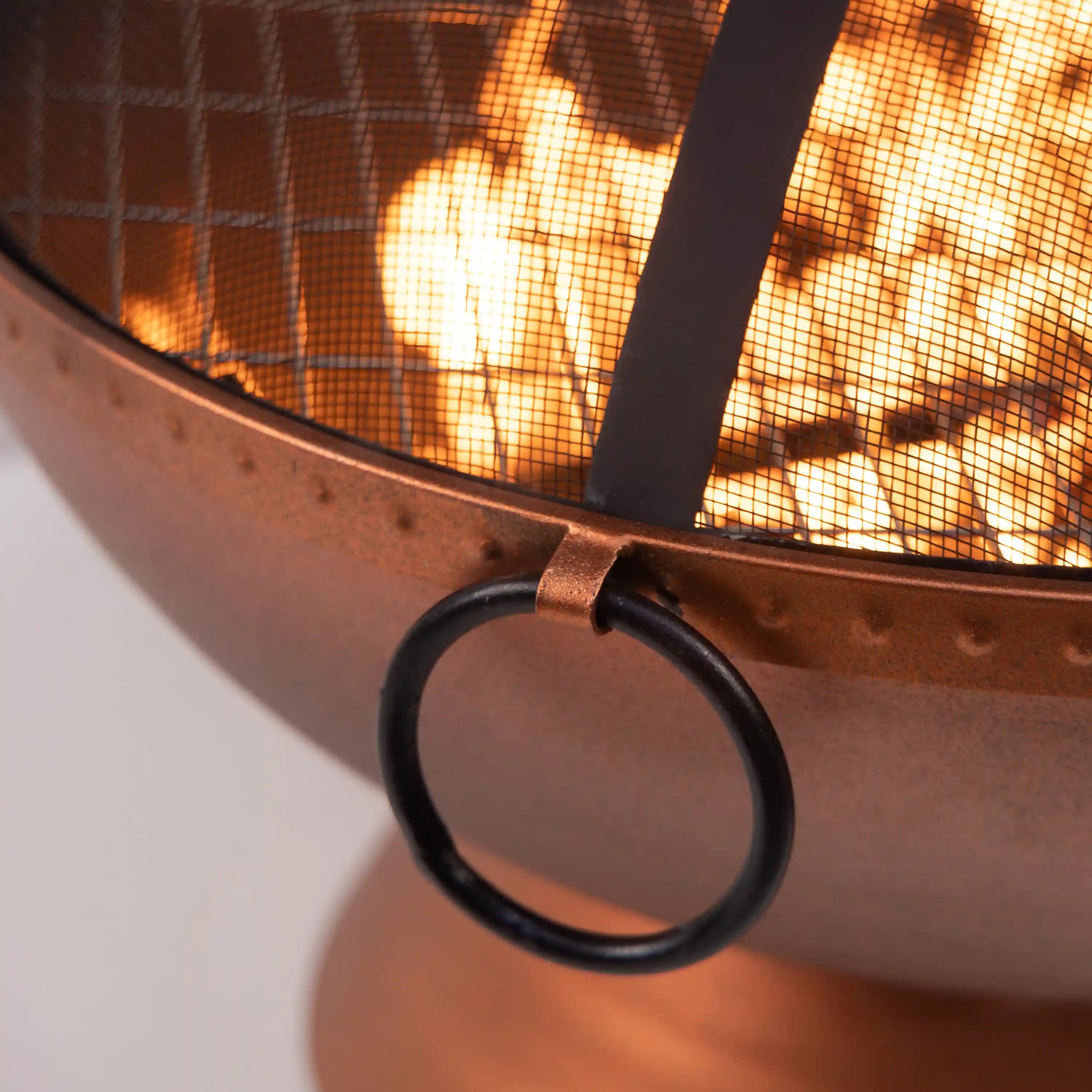 Close-up of curved firepit handle and mesh screen over burning fire