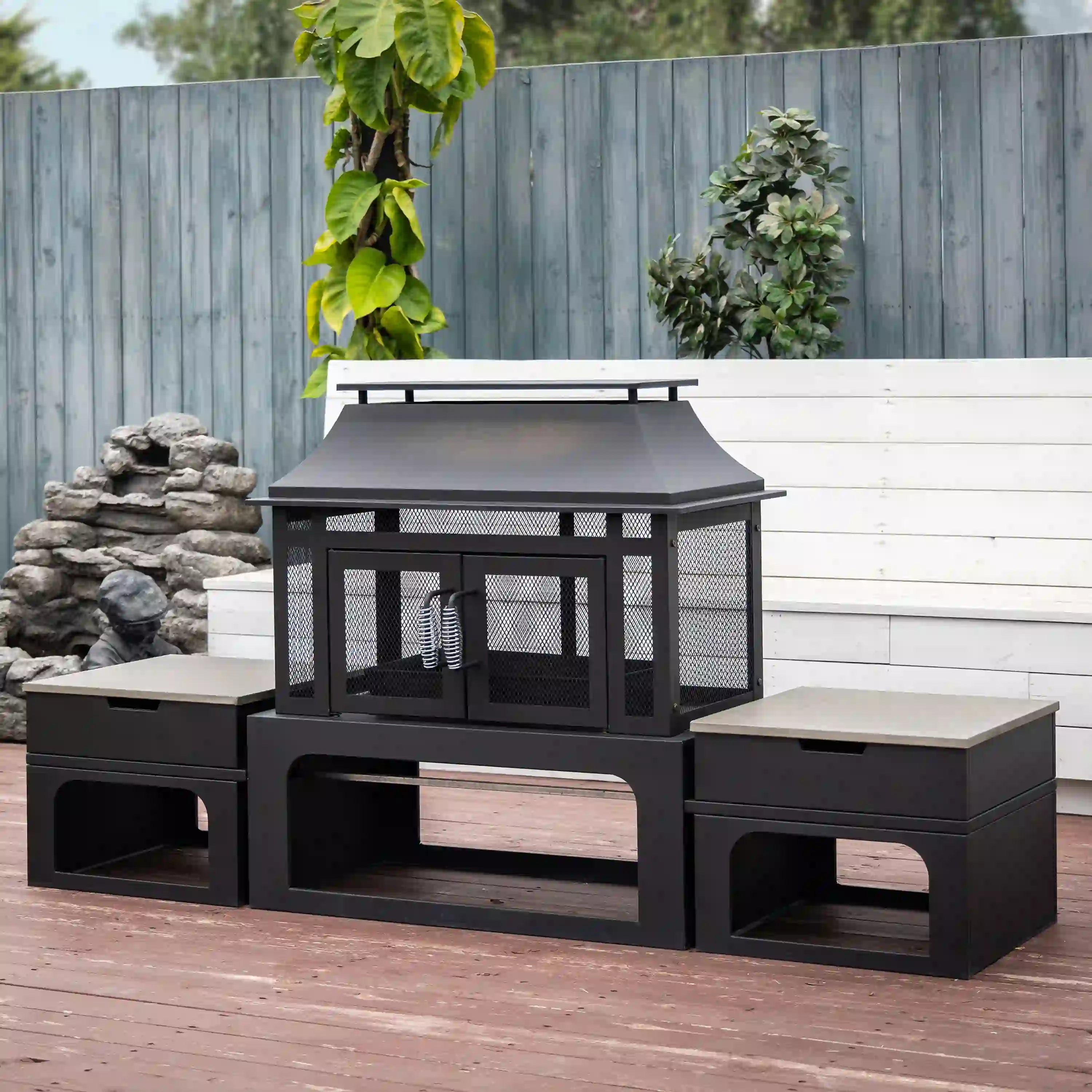 Outdoor rectangular steel wood-burning fireplace with log storage and side tables