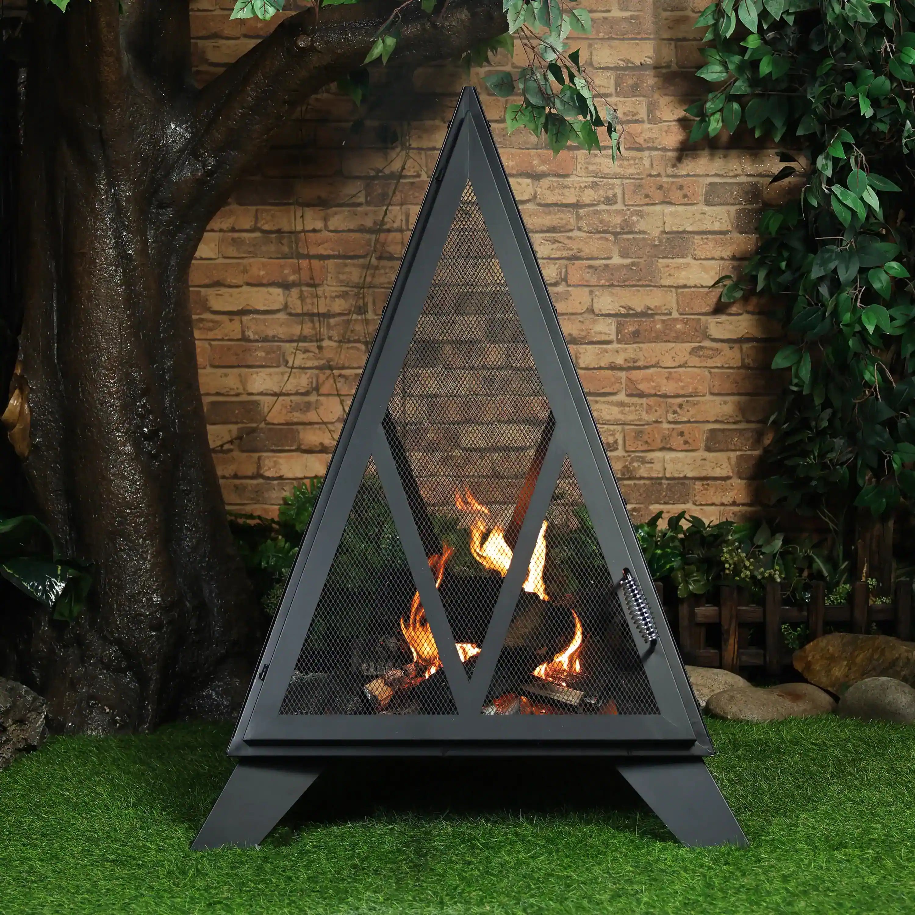 Outdoor black steel pyramid fire pit with mesh spark screen and visible flames