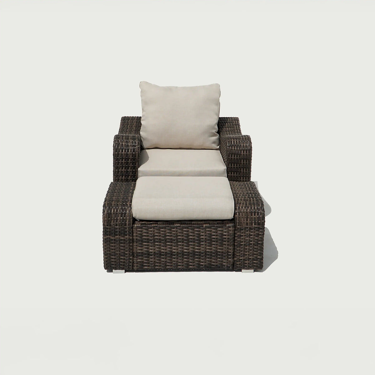Brown woven wicker outdoor lounge chair with beige cushion and back pillow