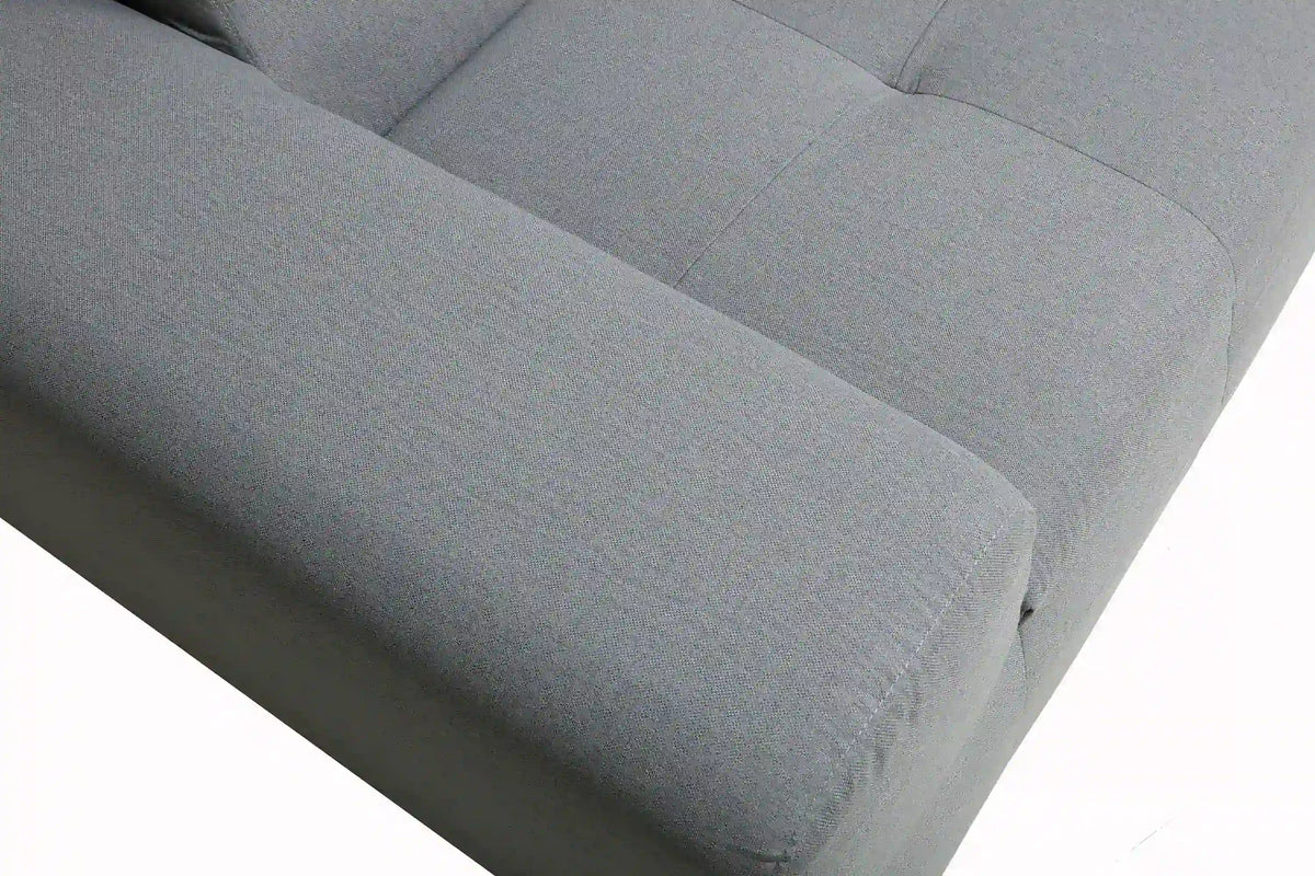 Gray upholstered outdoor sectional seat cushion with stitched seam and rounded corner