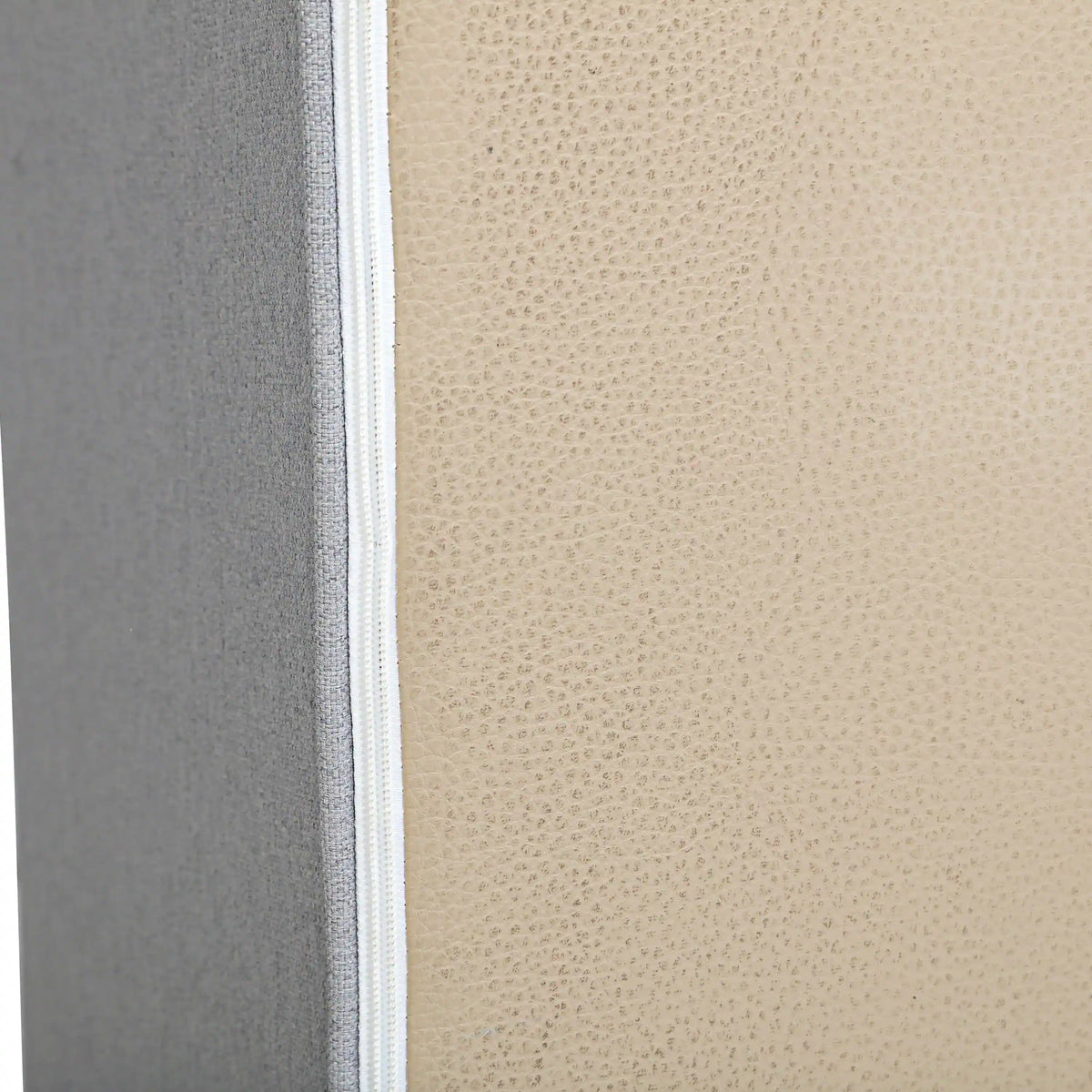 Close-up of gray textured outdoor fabric on sofa arm with white seam trim