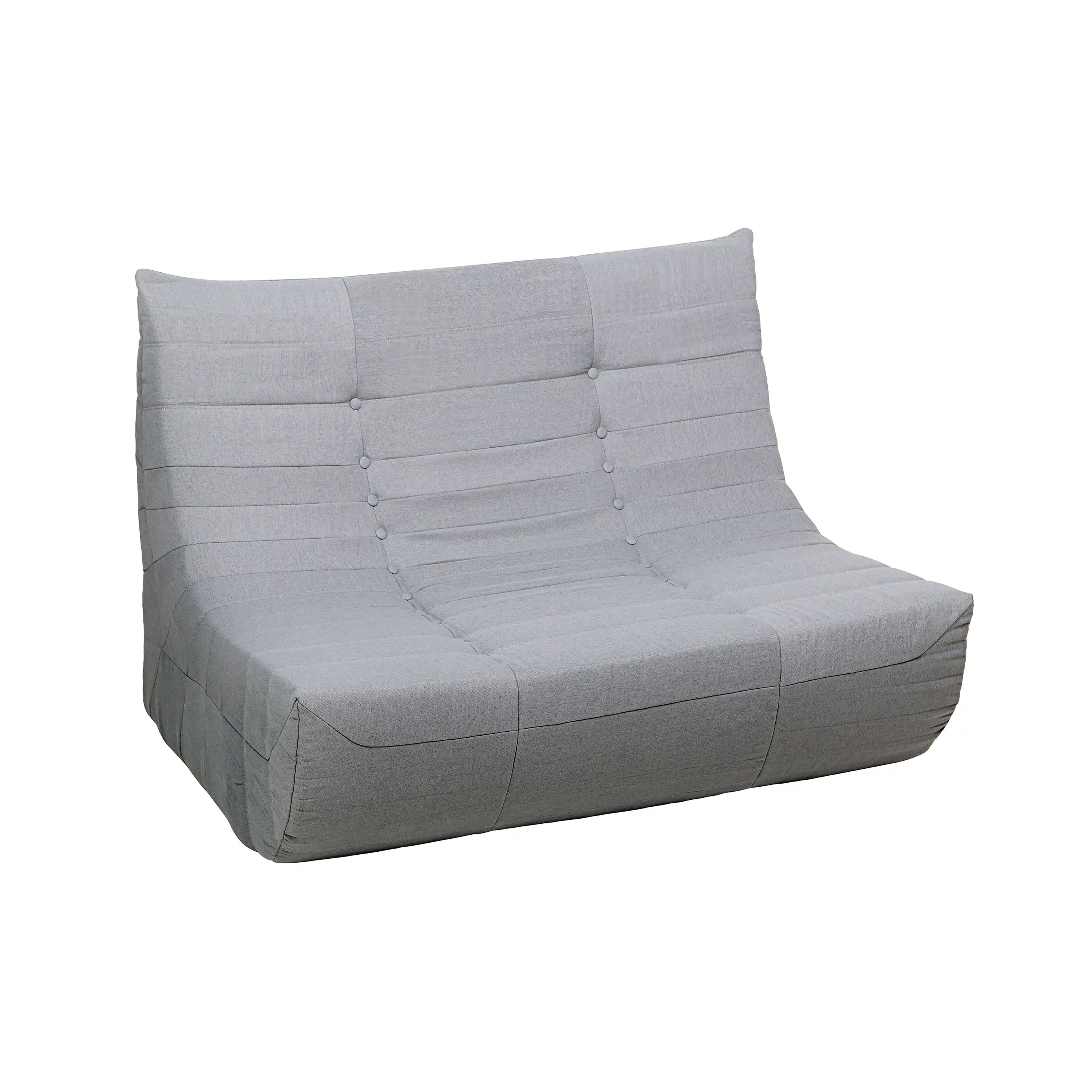 Gray outdoor compressed foam sofa with tufted back, wide arms, and boxy seat