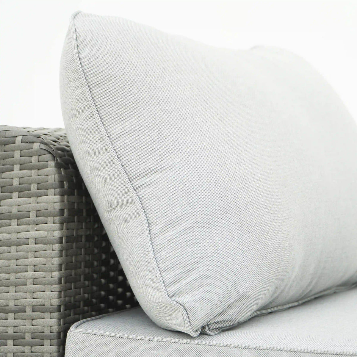 Gray outdoor sectional sofa cushion with welt seam on wicker arm