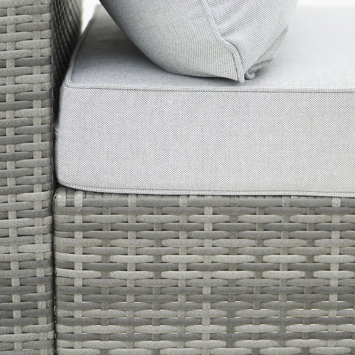 Gray outdoor wicker sectional sofa arm with light gray cushion and stitched seam