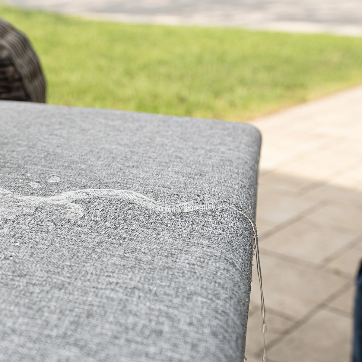 Close-up of gray cushion corner on outdoor wicker chair
