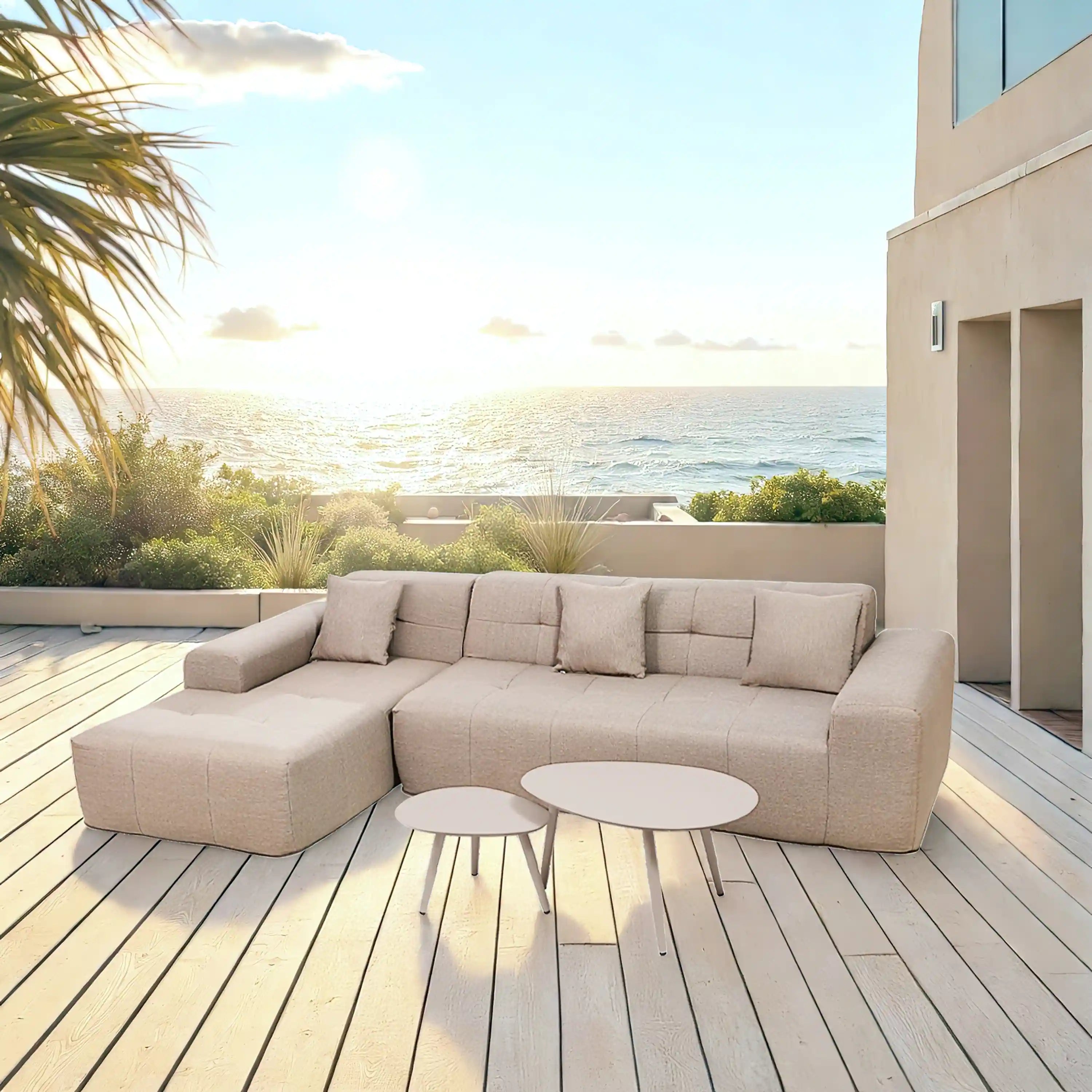 Tan sectional sofa with chaise seating and two round outdoor side tables