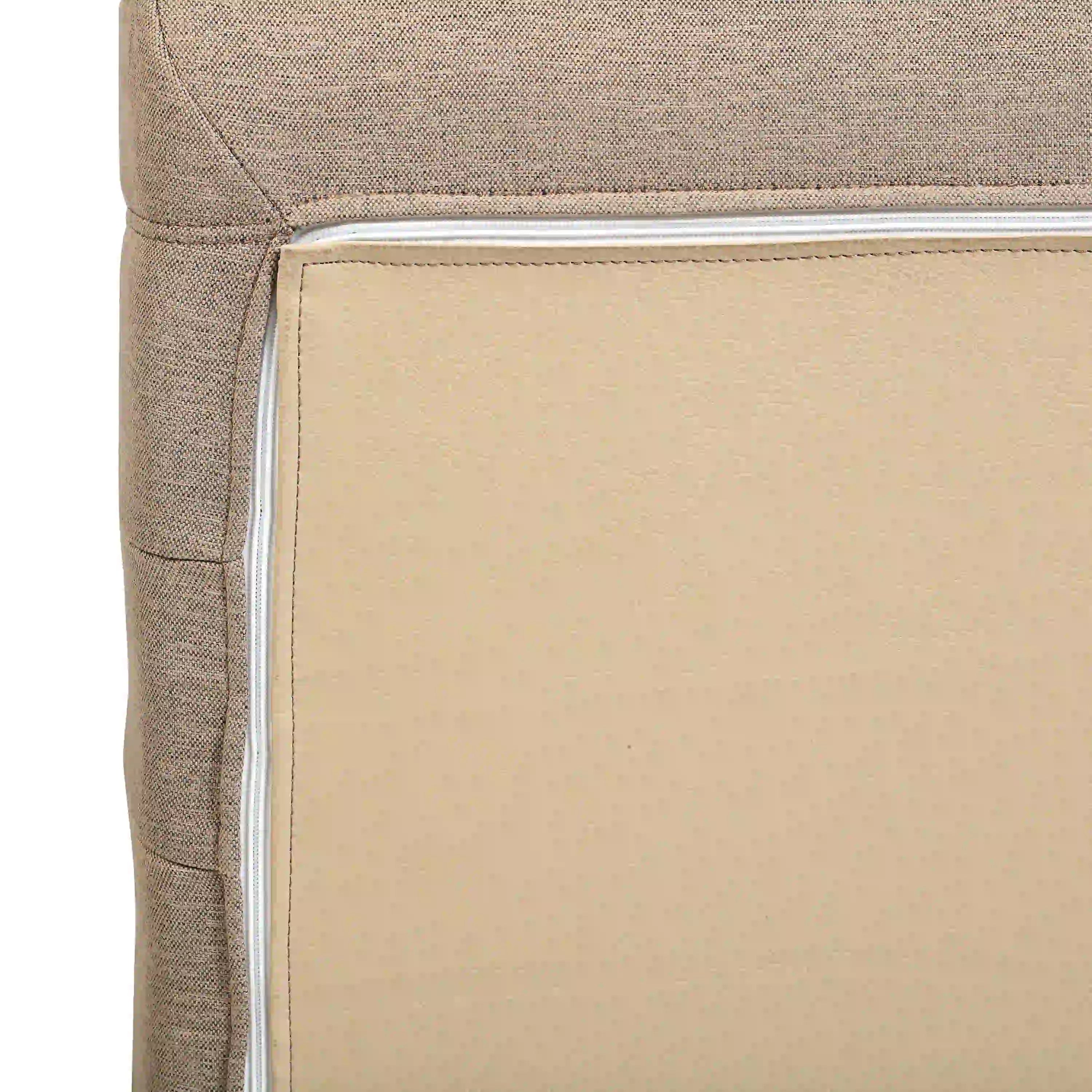 Tan upholstered cushion corner with visible piping and clean seam stitching