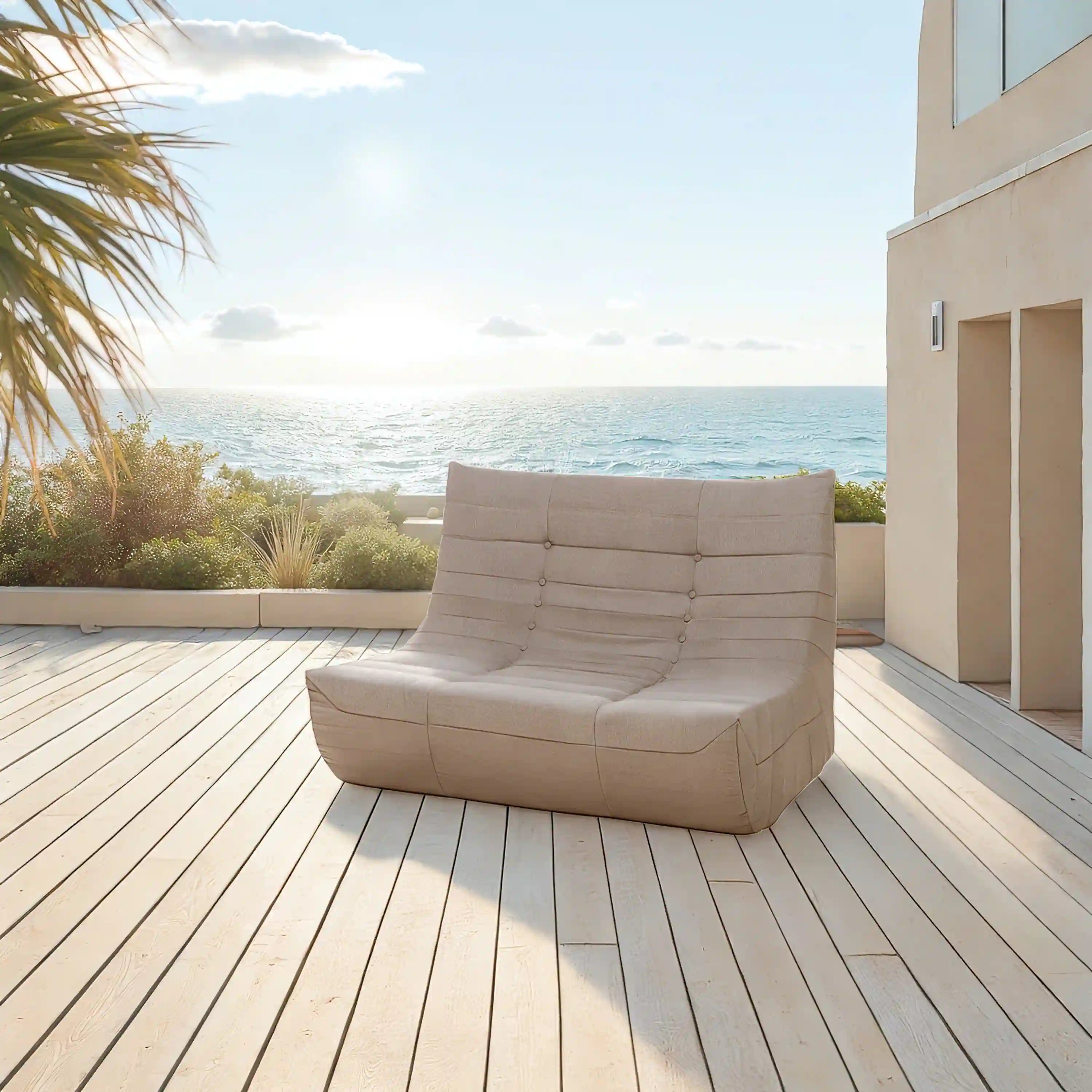 Brown outdoor sofa with tufted back and seat cushions on a deck