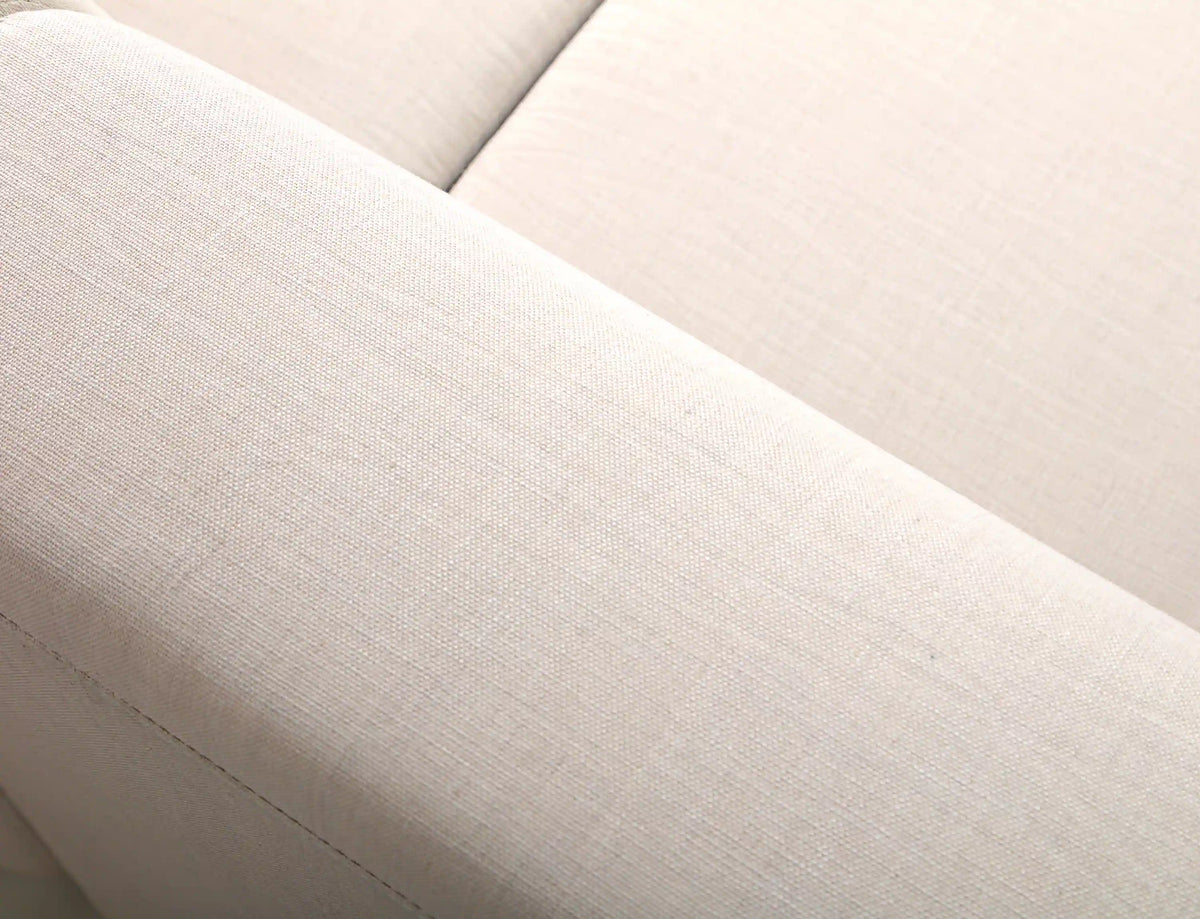 Beige seat cushion with stitched edge seam on outdoor sectional sofa