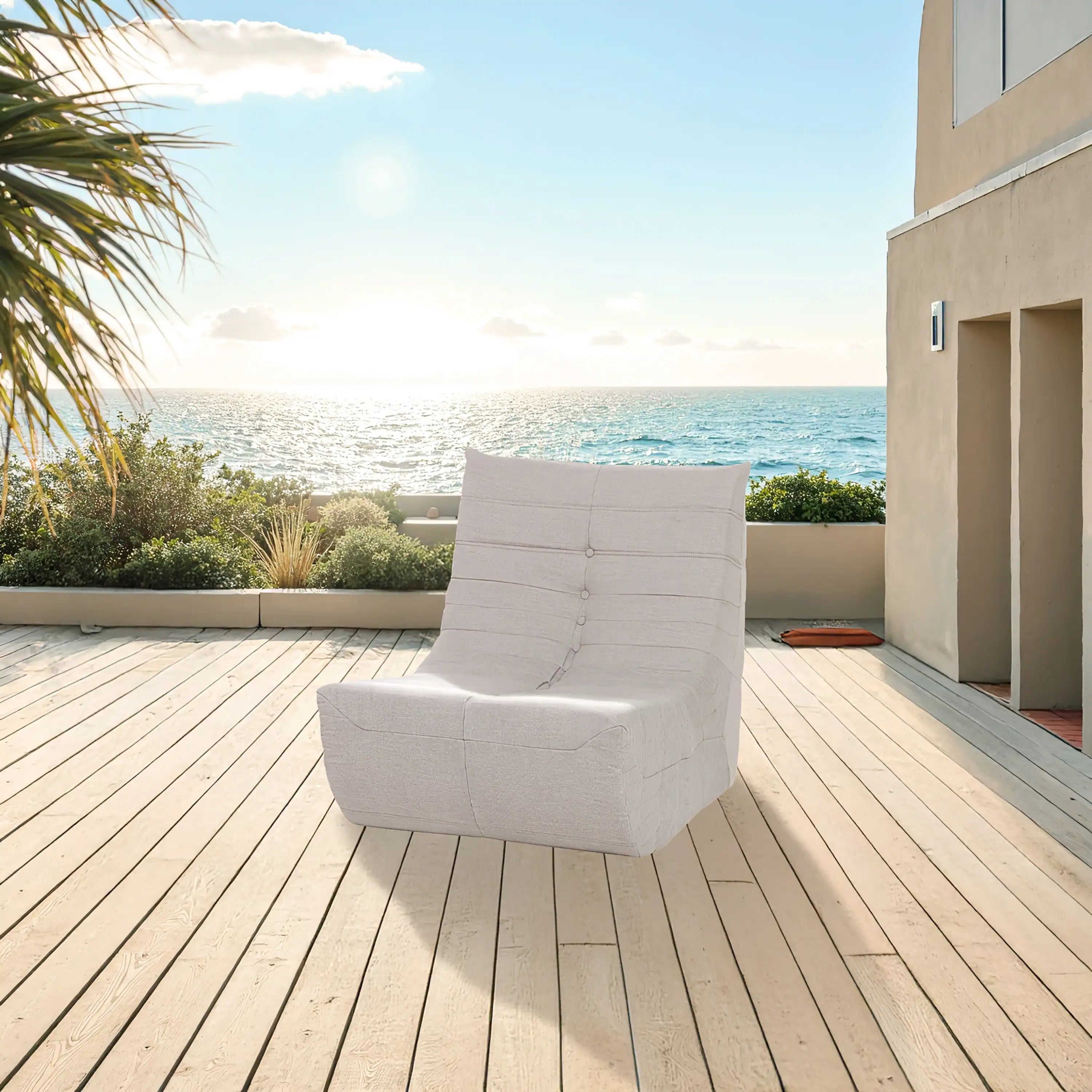 Beige outdoor compressed foam chair with tufted back and rounded arms on wooden deck