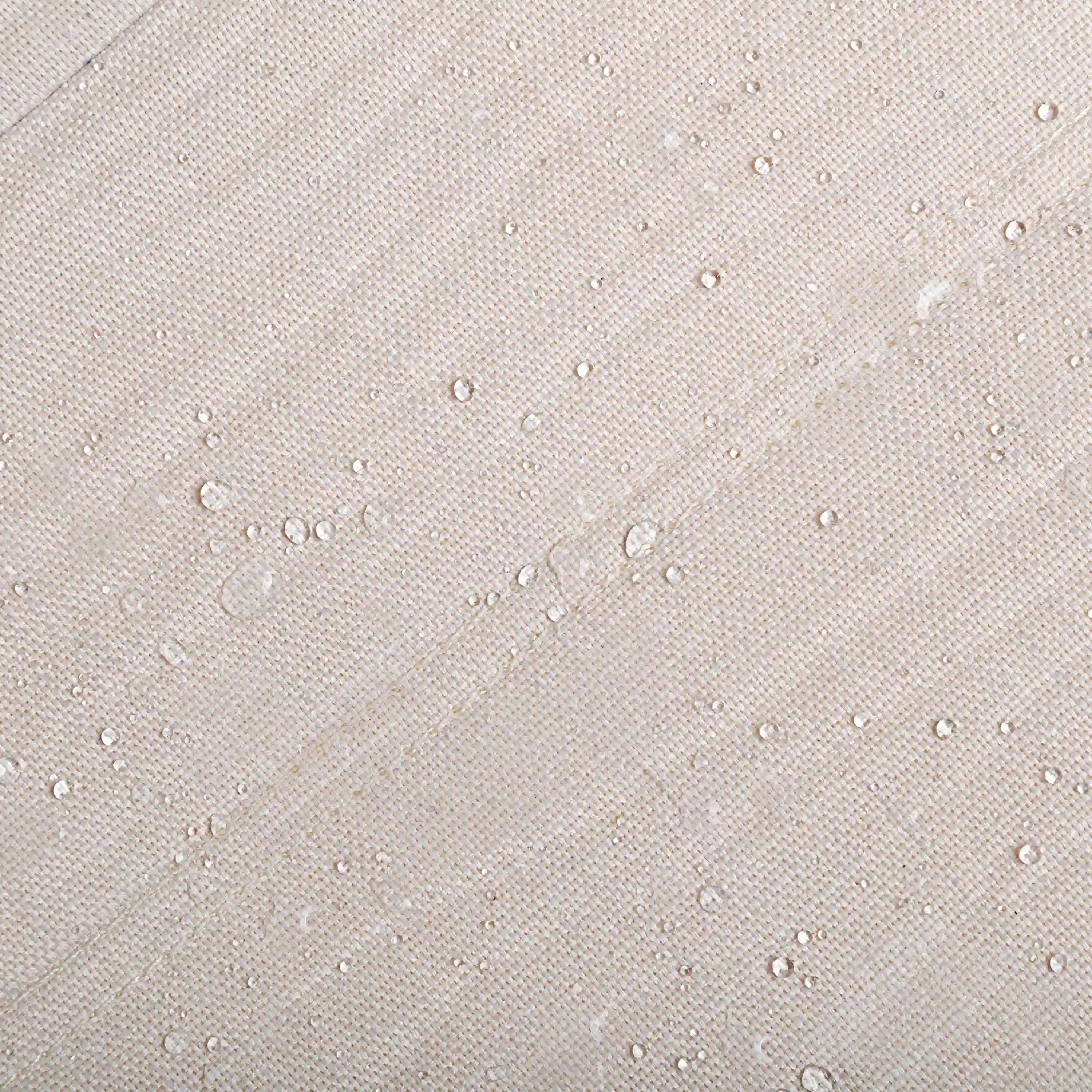Beige textured outdoor chair fabric with water droplets for water-resistant coverage