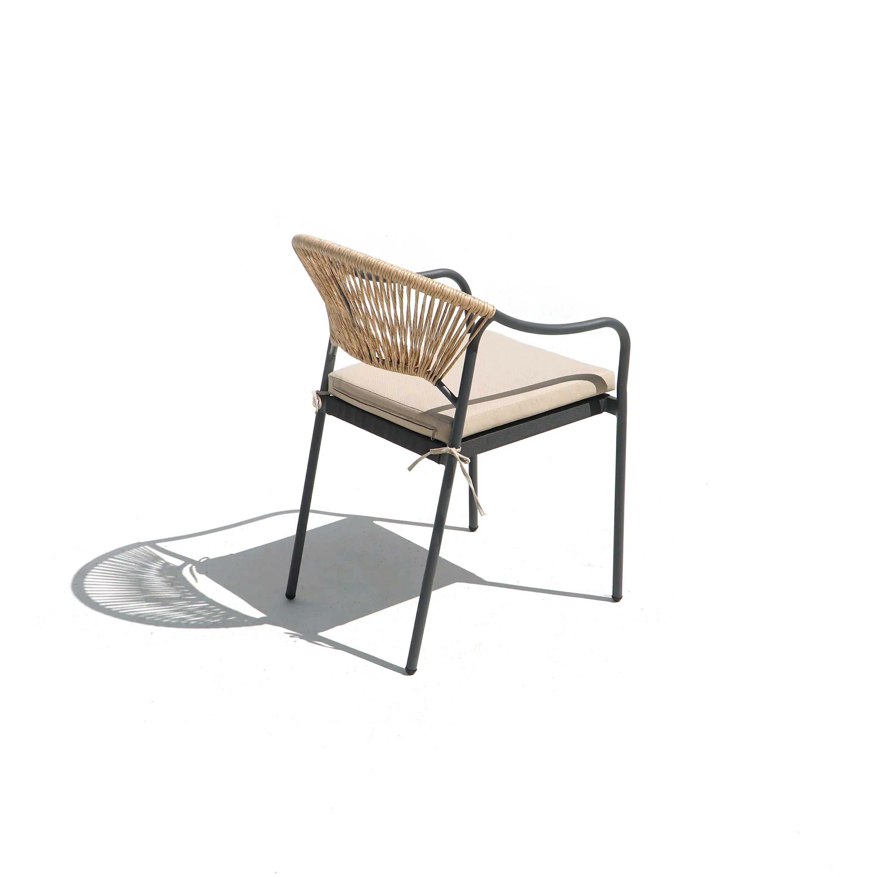 Outdoor patio chair with curved woven wicker backrest and beige cushion on dark metal frame.