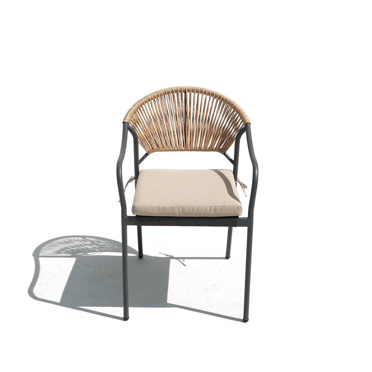 Outdoor dining chair with woven wicker back, dark frame, and light beige cushion.