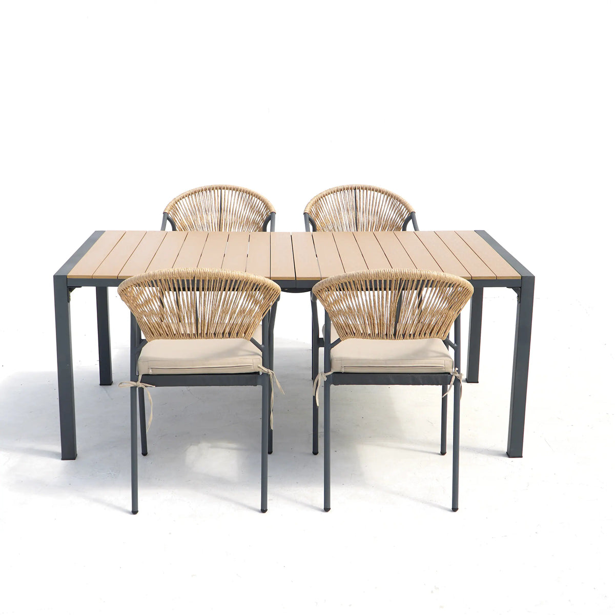 Outdoor patio dining table with four wicker chairs; light beige seat cushions and dark frames.
