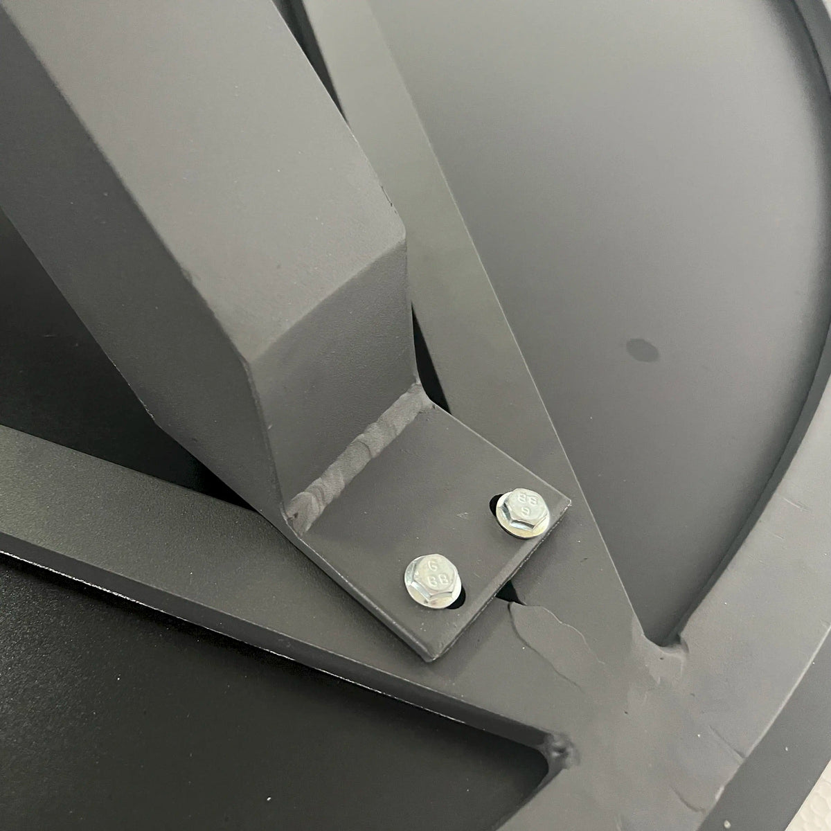 Grey outdoor stackable chair frame corner with leg and round caps detail