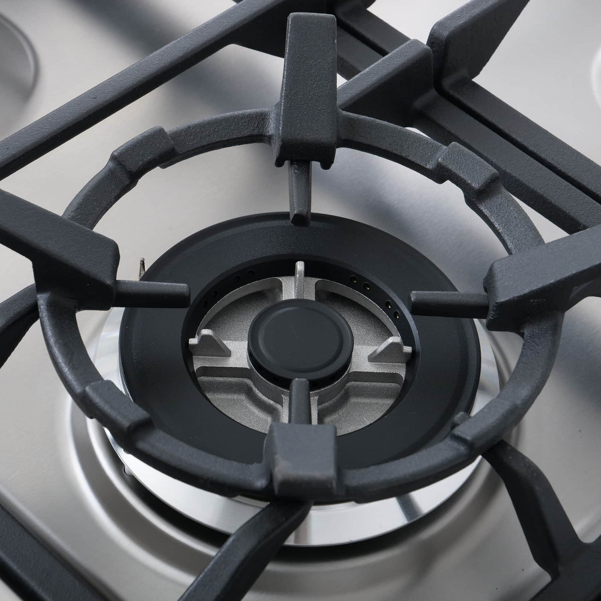Stainless steel gas cooktop burner with black grates and center cap